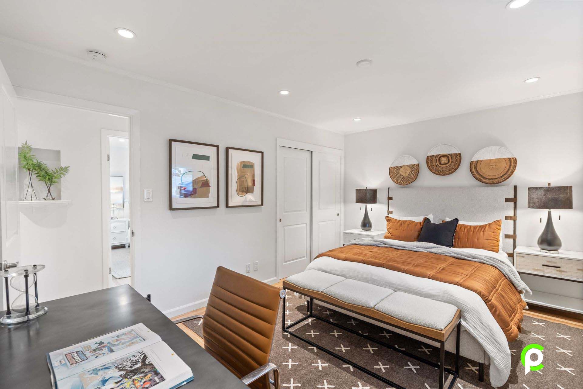 A bedroom with a large bed , desk and chair.