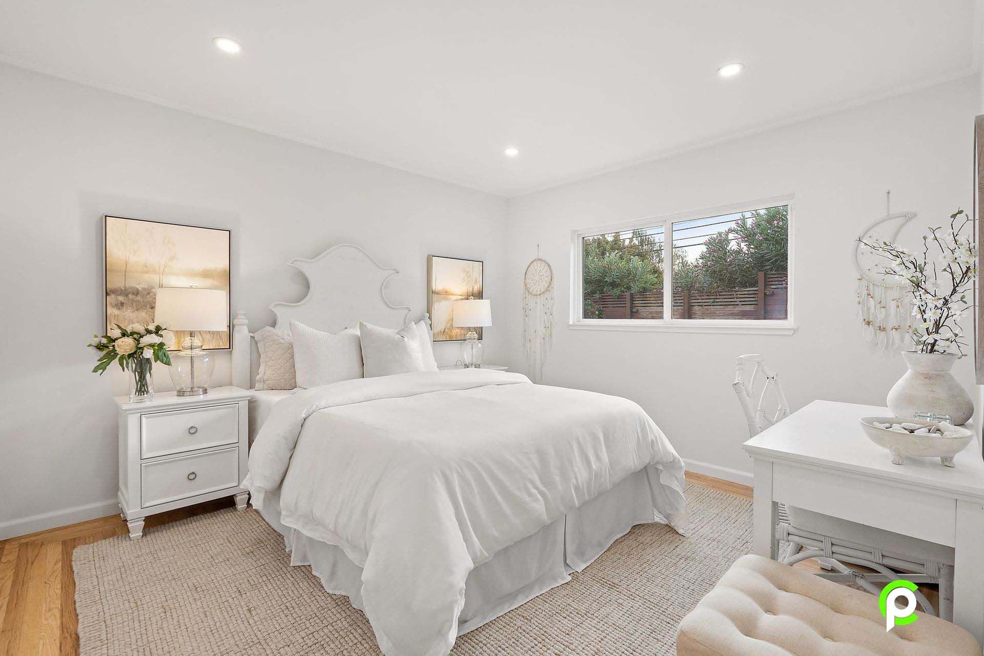 A bedroom with a bed , nightstand , dresser and window.