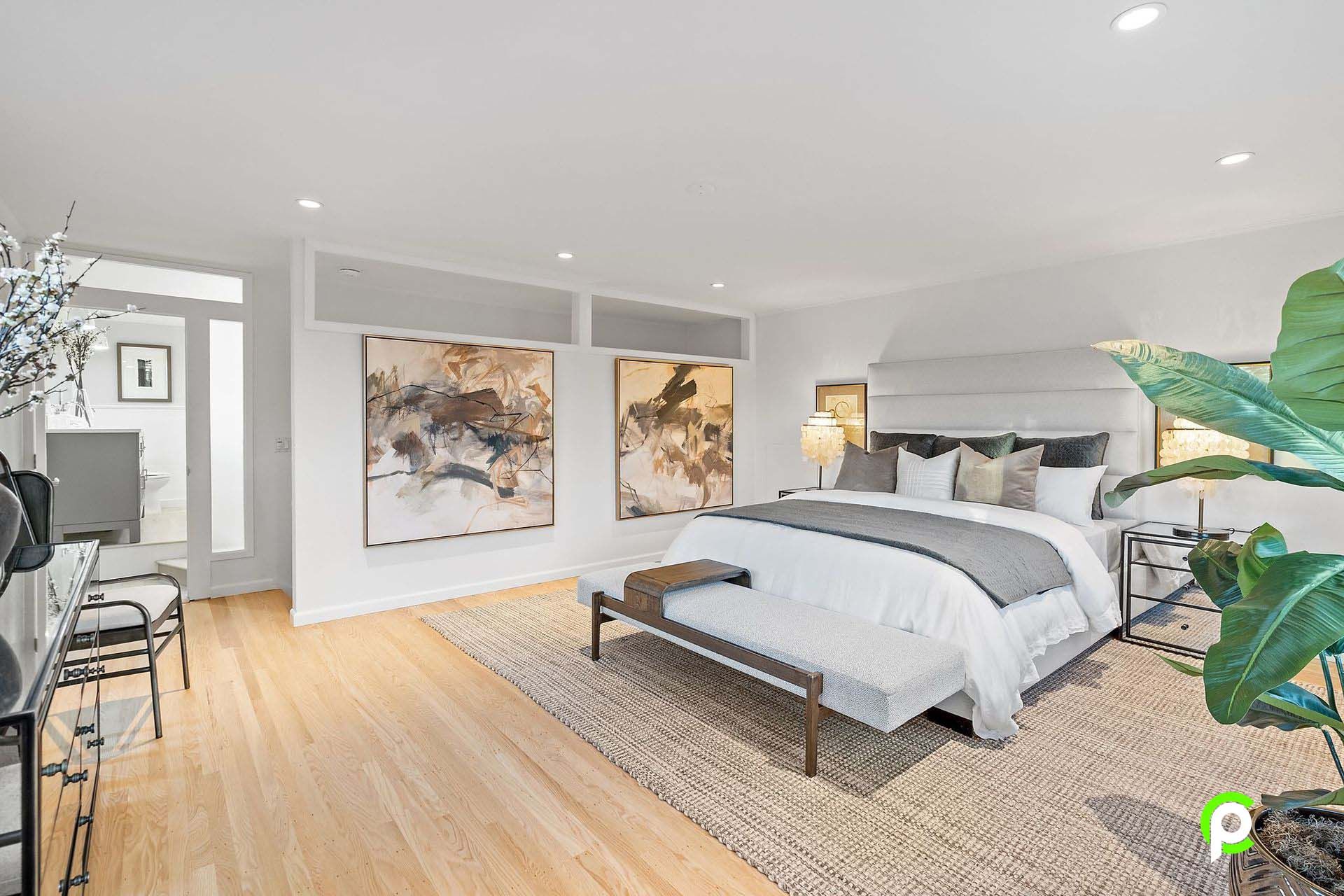 A bedroom with a large bed and a bench in it.