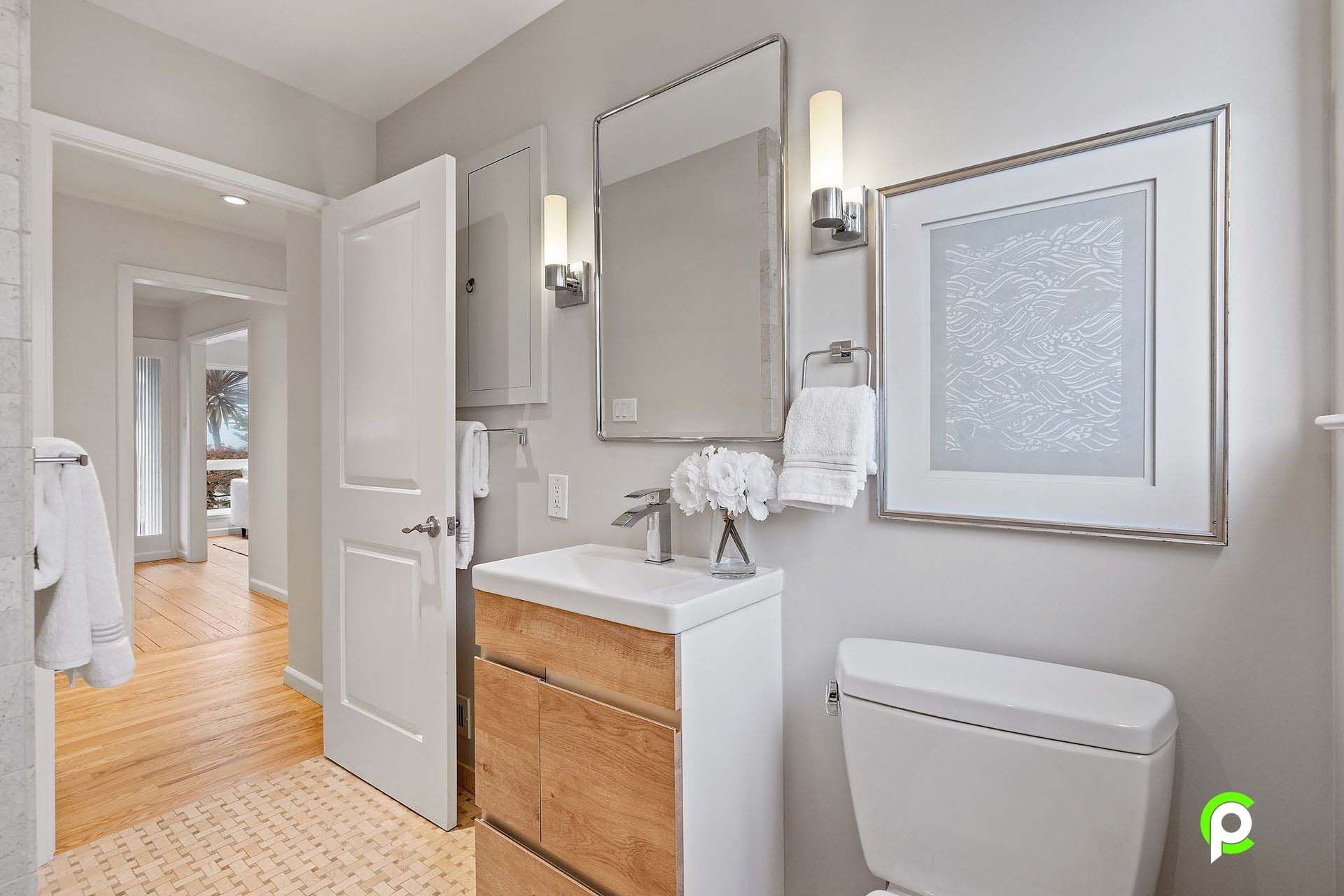 A bathroom with a sink , toilet and mirror.