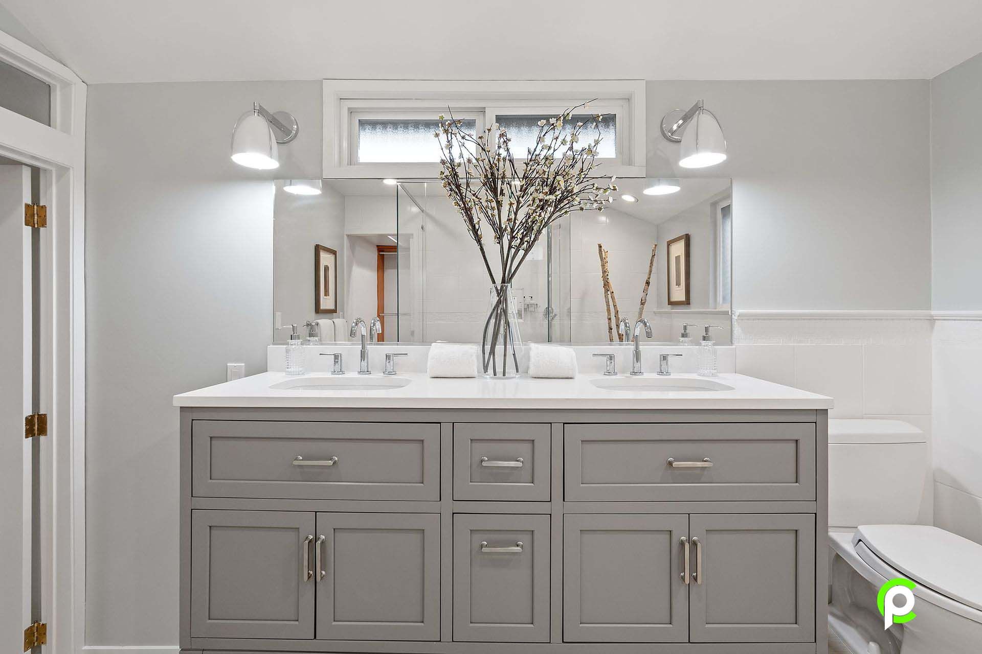 A bathroom with two sinks and a large mirror.