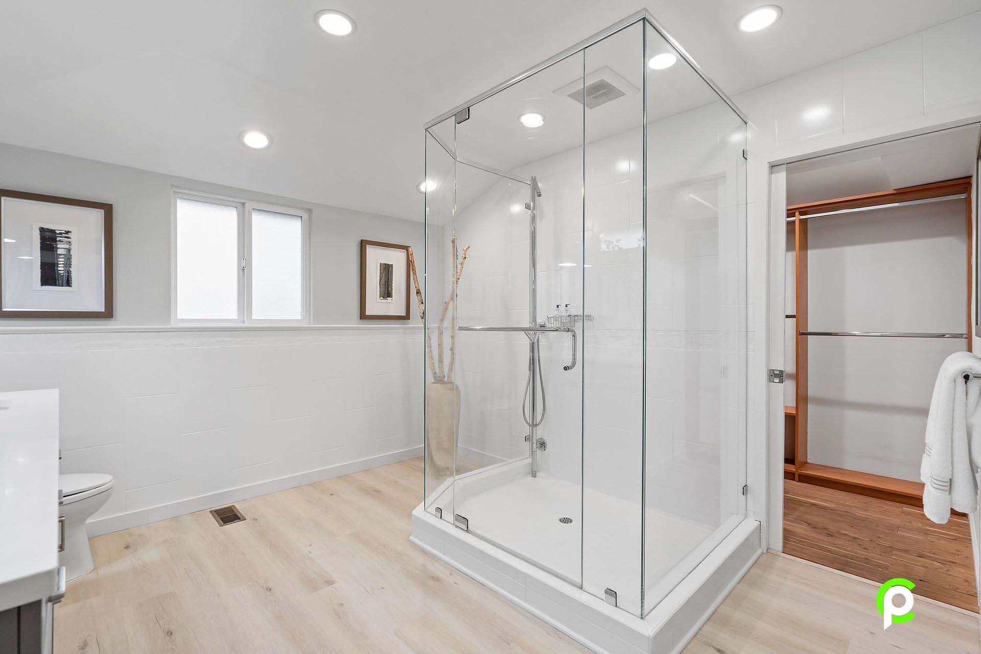 A bathroom with a walk in shower and a sink.