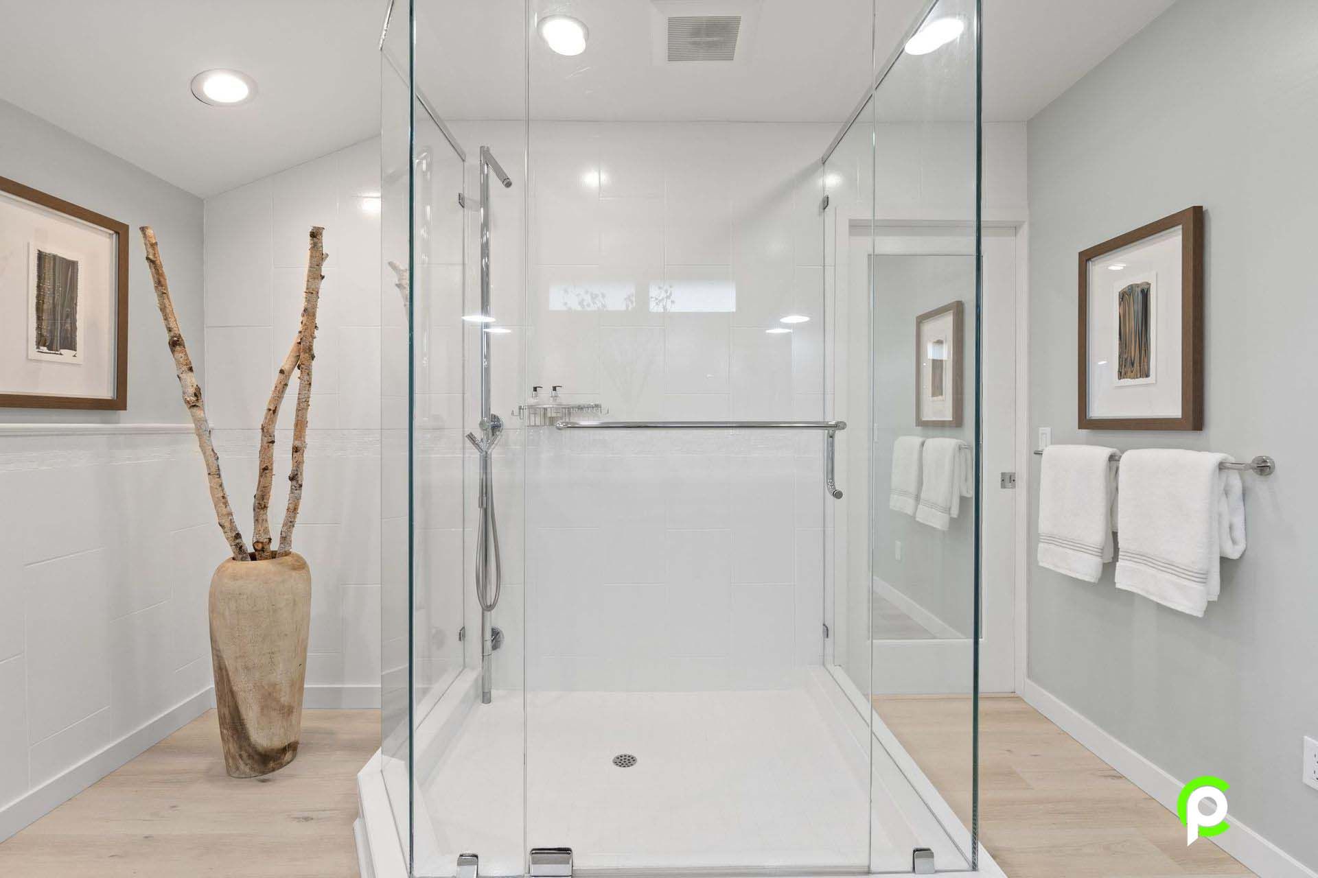 A bathroom with a walk in shower and a glass door.