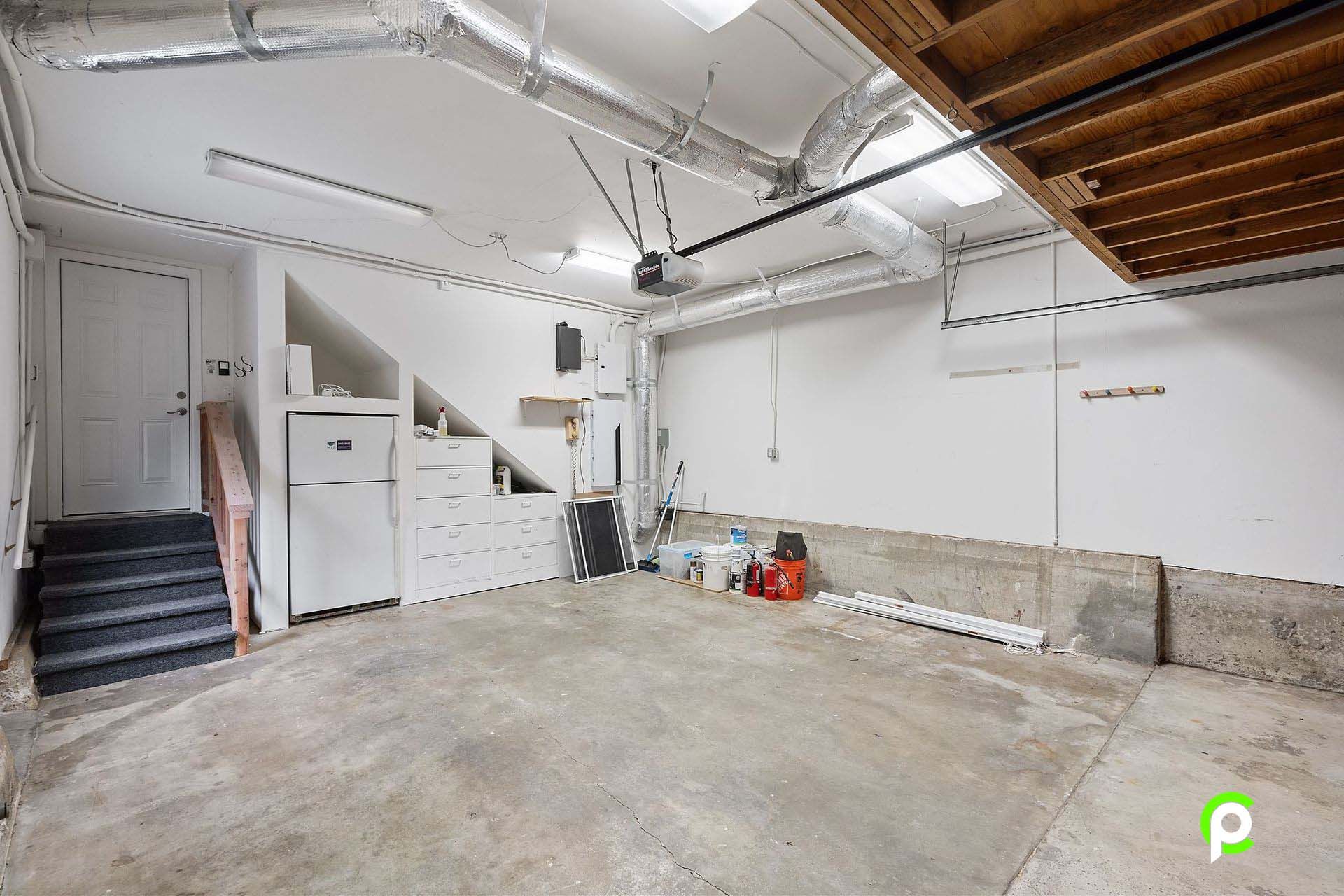 An empty garage with a staircase leading up to it