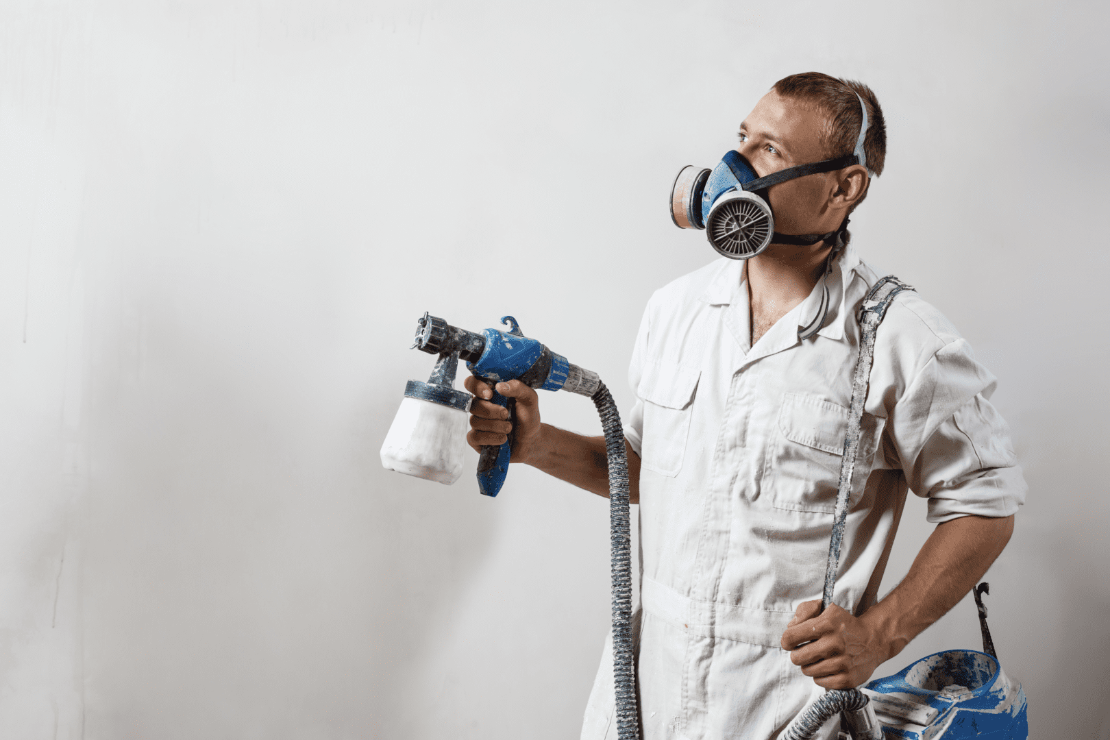 A man wearing white while holding a paint