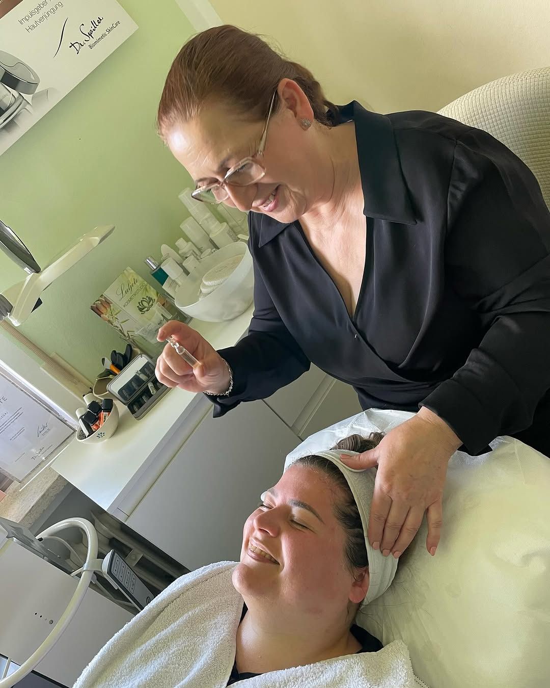 Eine Frau gibt einer anderen Frau in einem Spa eine Gesichtsbehandlung.