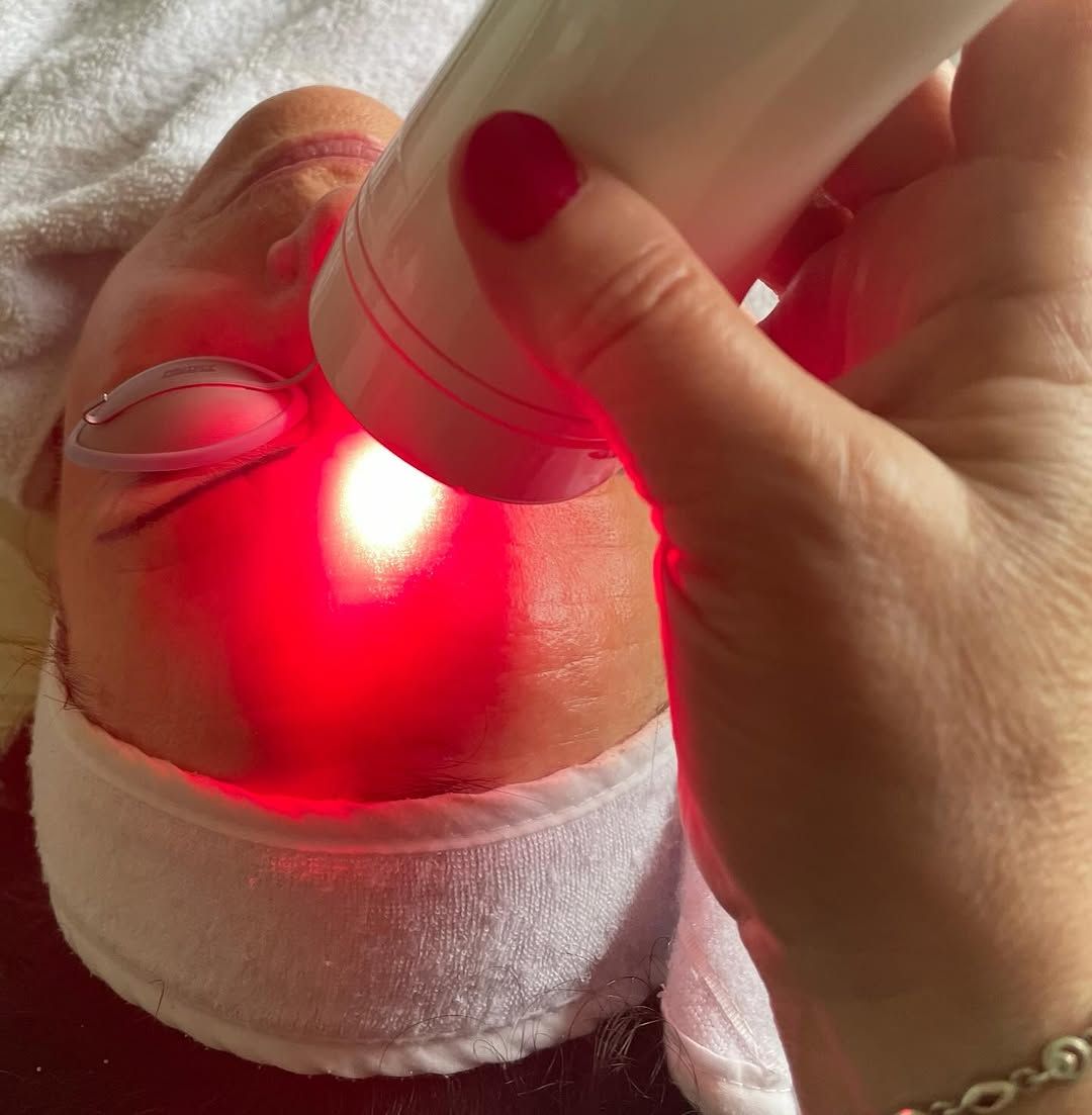 Eine Frau bekommt eine Rotlichtbehandlung im Gesicht