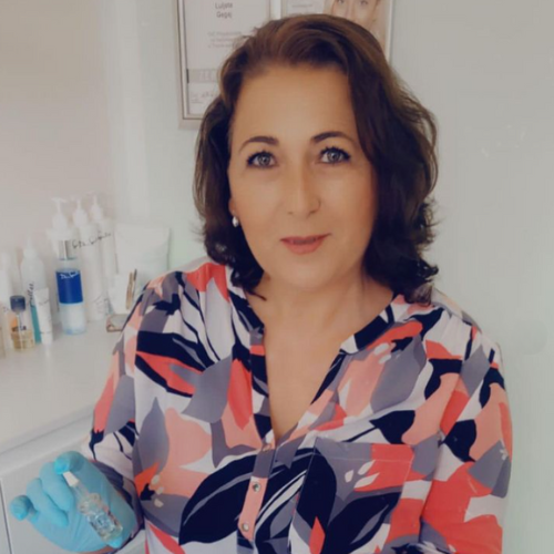 Eine Frau mit geblümtem Hemd und blauen Handschuhen