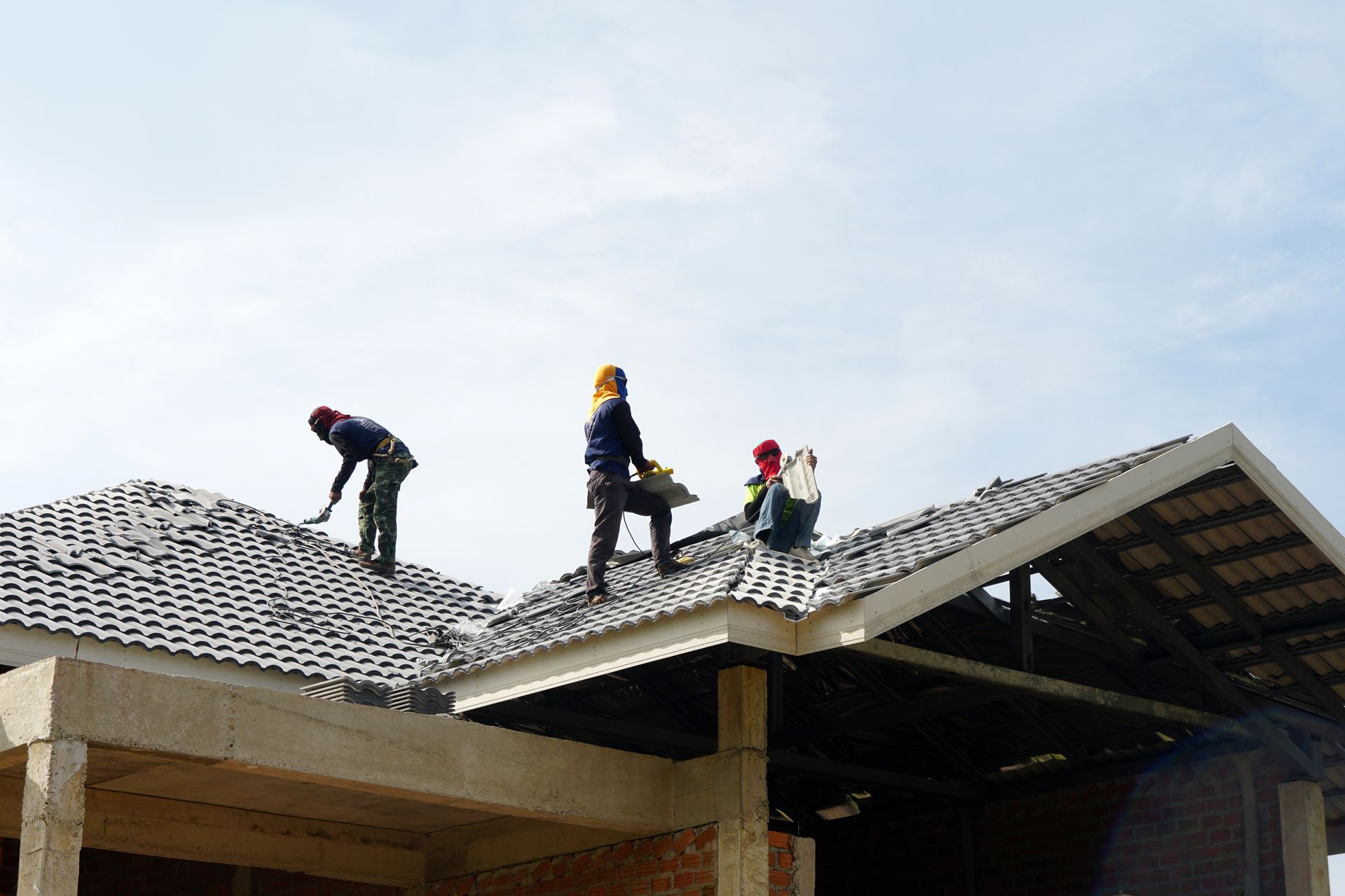 Construction Workers Installing Roof Tiles on A Building — Newcastle Roofing Wizards In Tingira Heights, NSW