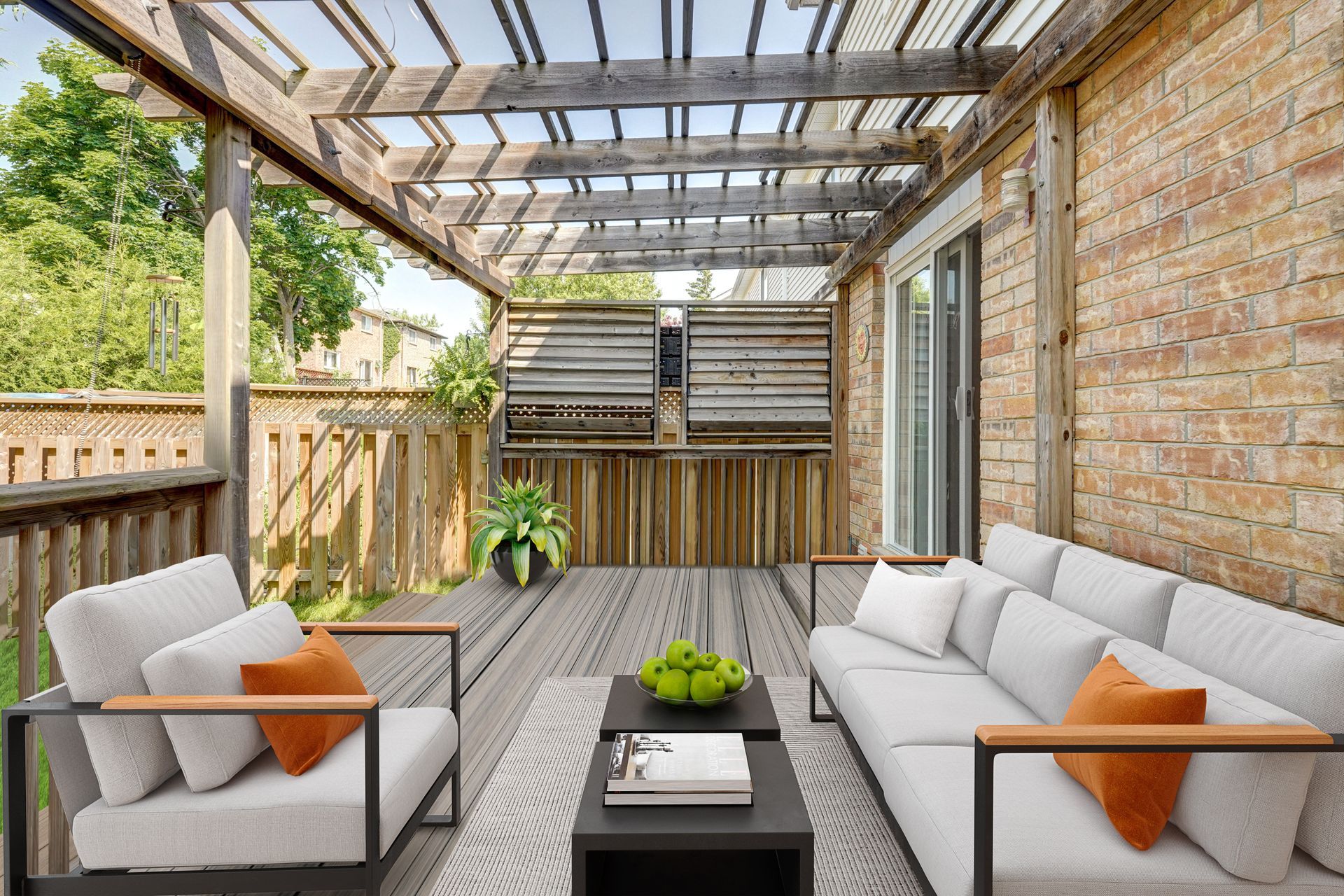 A patio with a couch , chairs and a table under a pergola.