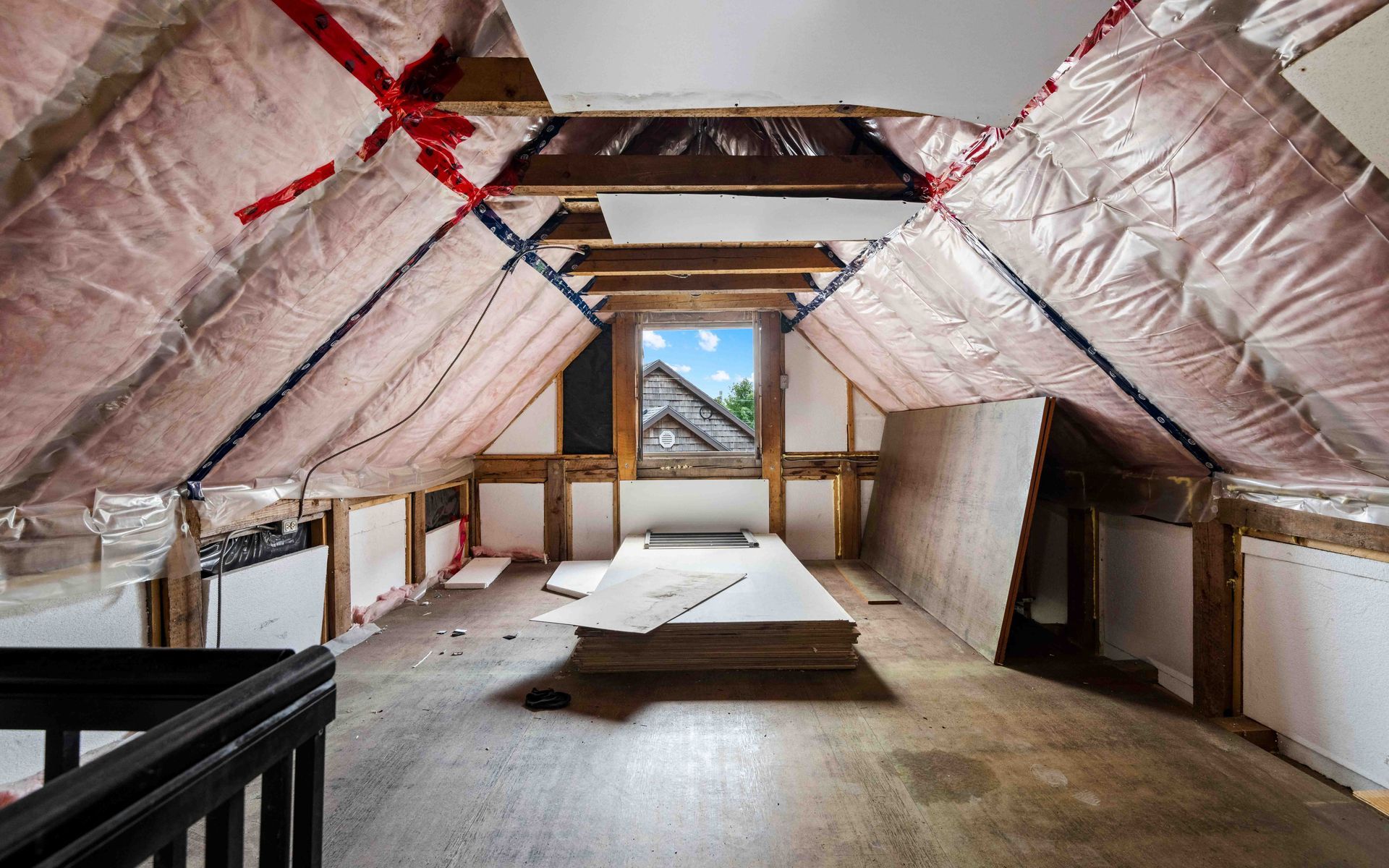 an attic with a lot of insulation and a window .