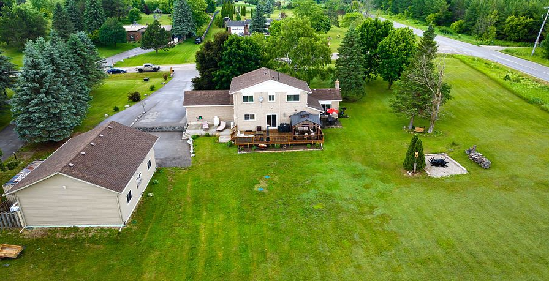 A large house with a large lawn and trees in front of it.