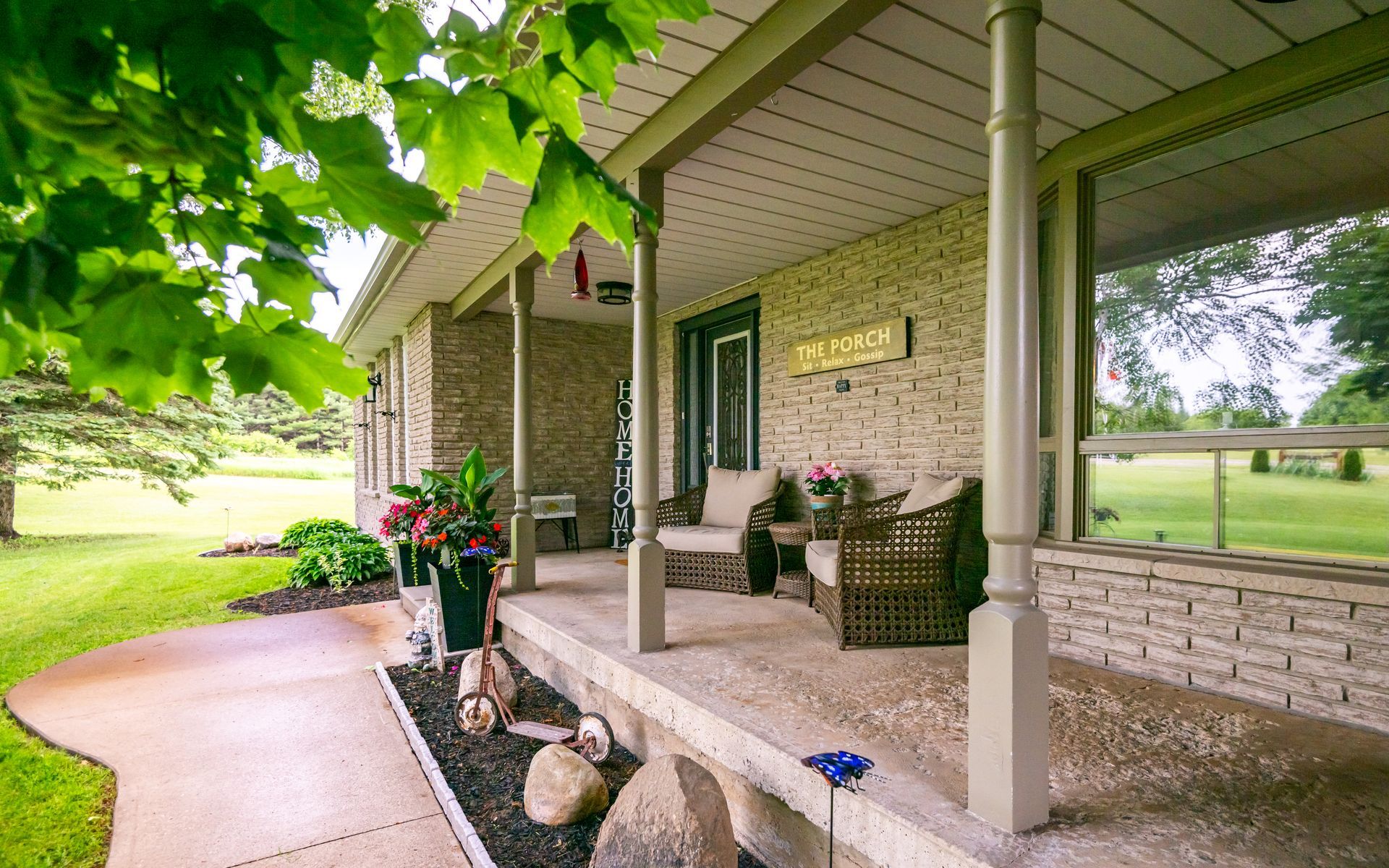 A brick house with a porch and a walkway leading to it.
