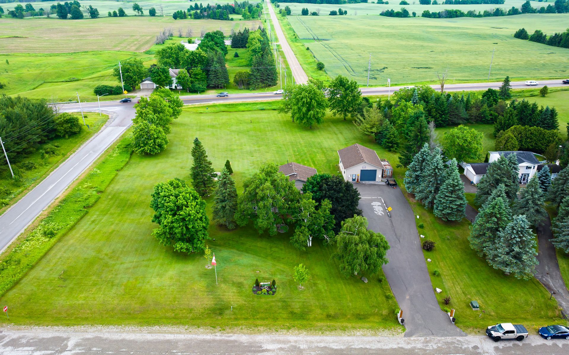 An aerial view of a house surrounded by trees and a road.