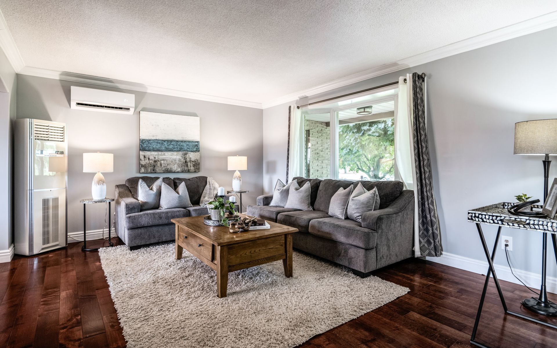 A living room with a couch , chair , coffee table and rug.