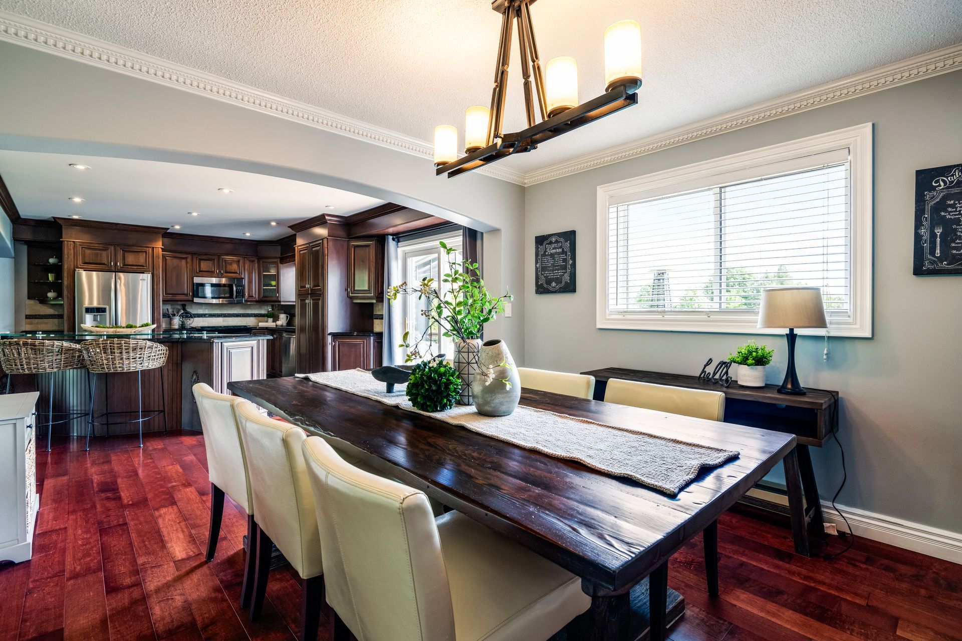 A dining room with a long wooden table and chairs and a chandelier.