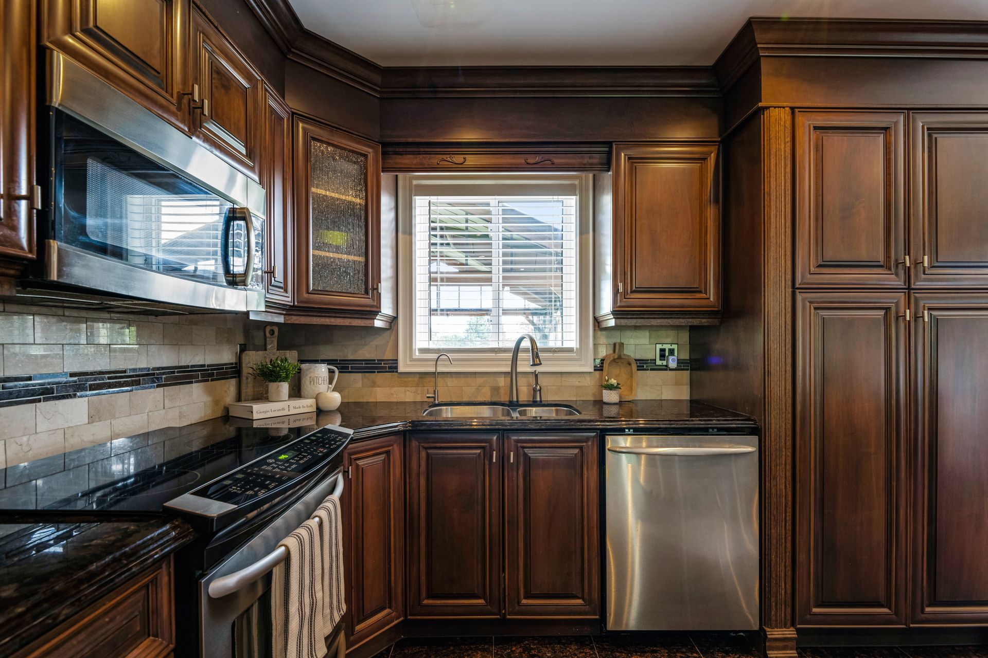 A kitchen with stainless steel appliances and wooden cabinets.
