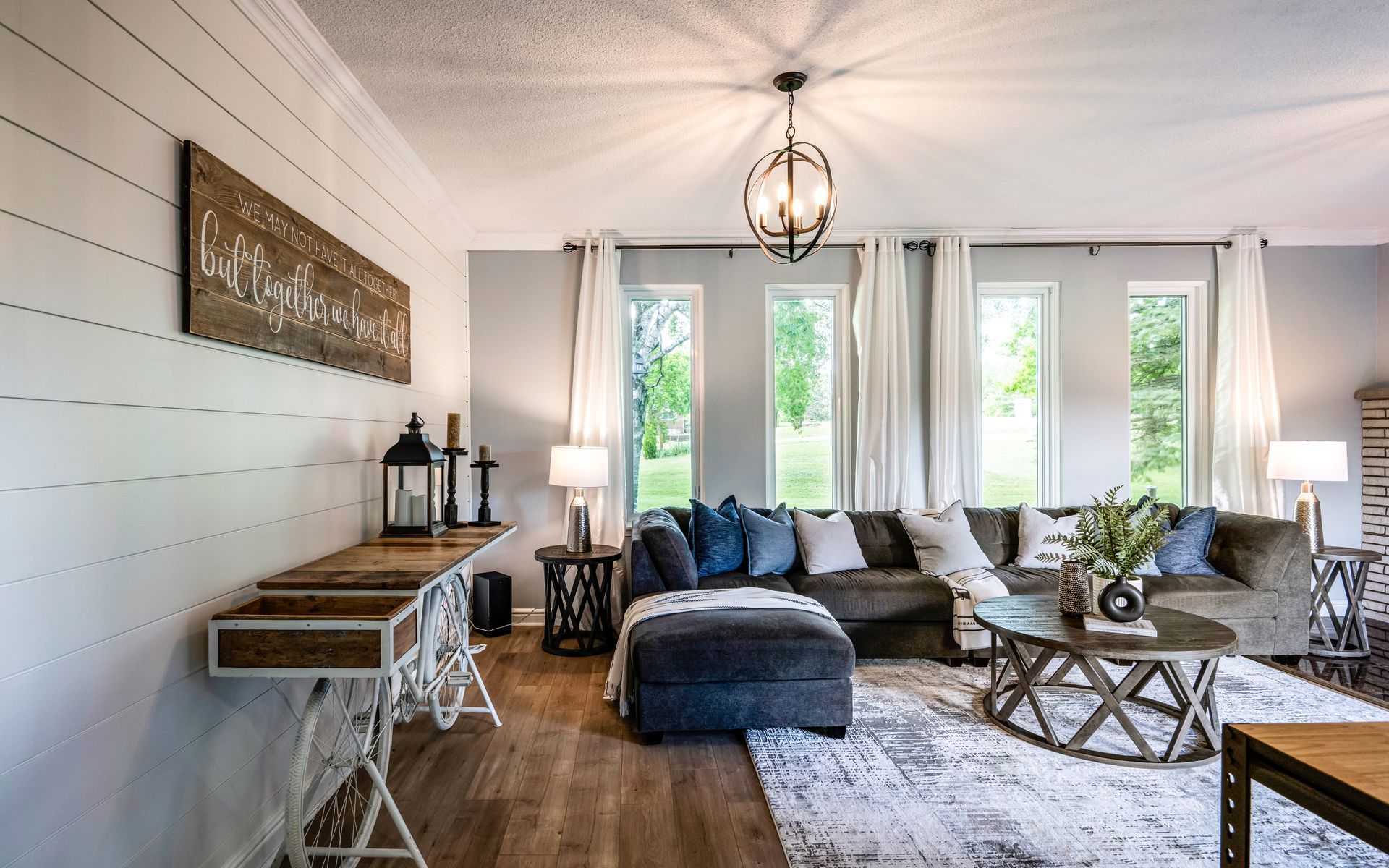 A living room with a couch , ottoman , coffee table , and desk.