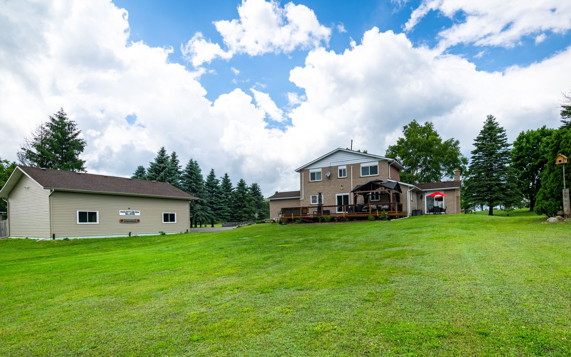 A large house is sitting on top of a lush green field.