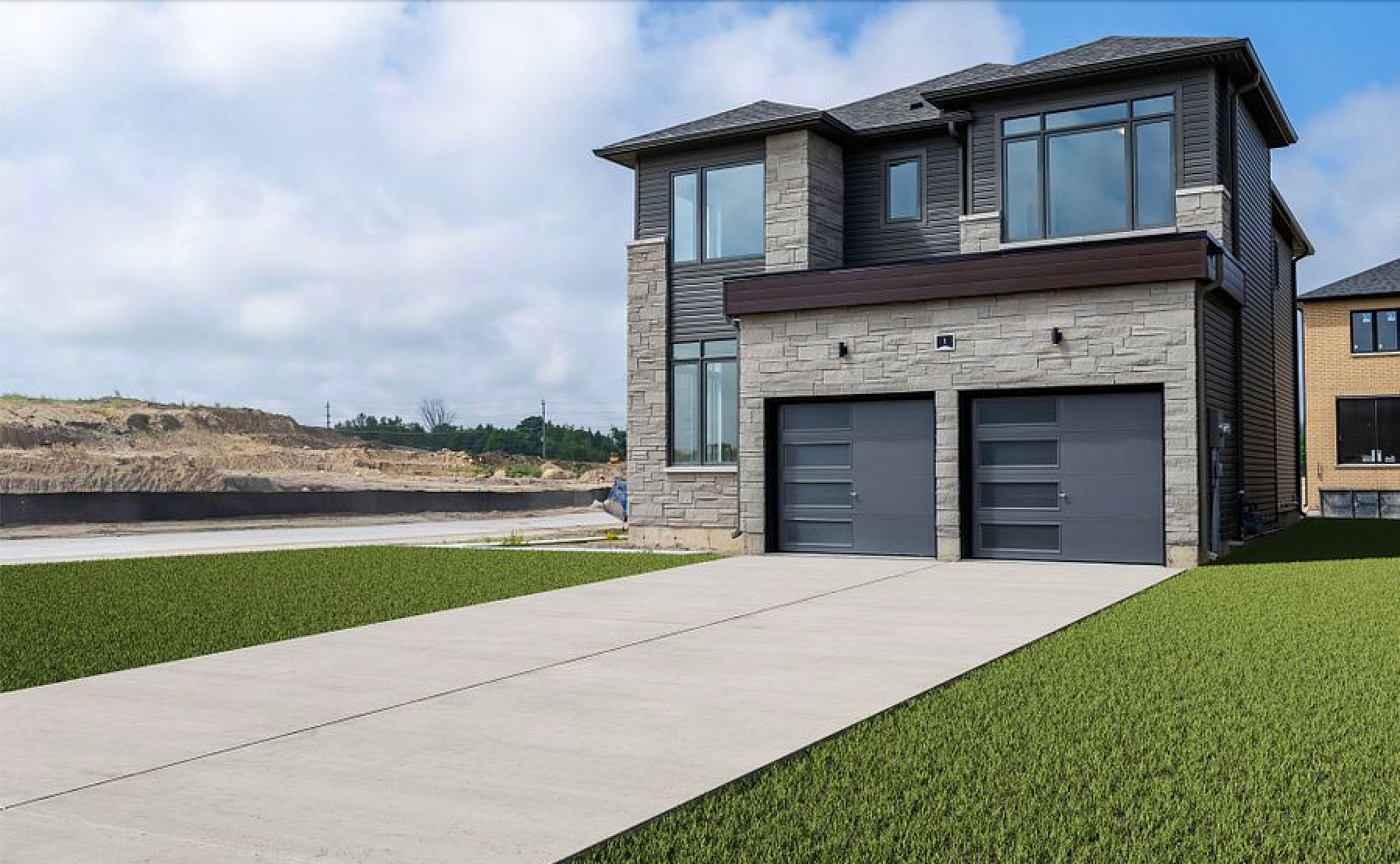 A large house with two garages and a driveway in front of it.