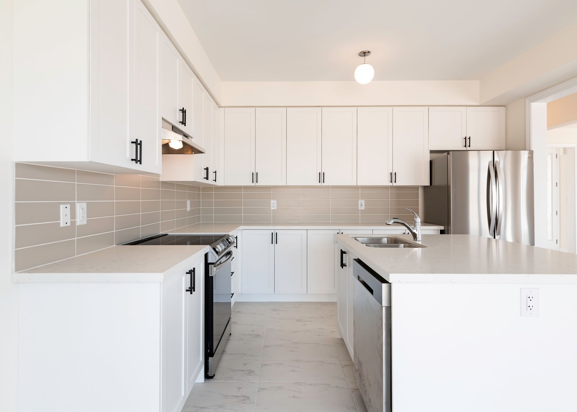 A kitchen with white cabinets and stainless steel appliances.