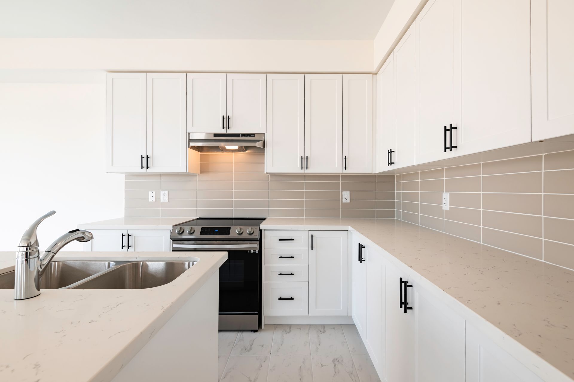 A kitchen with white cabinets and stainless steel appliances