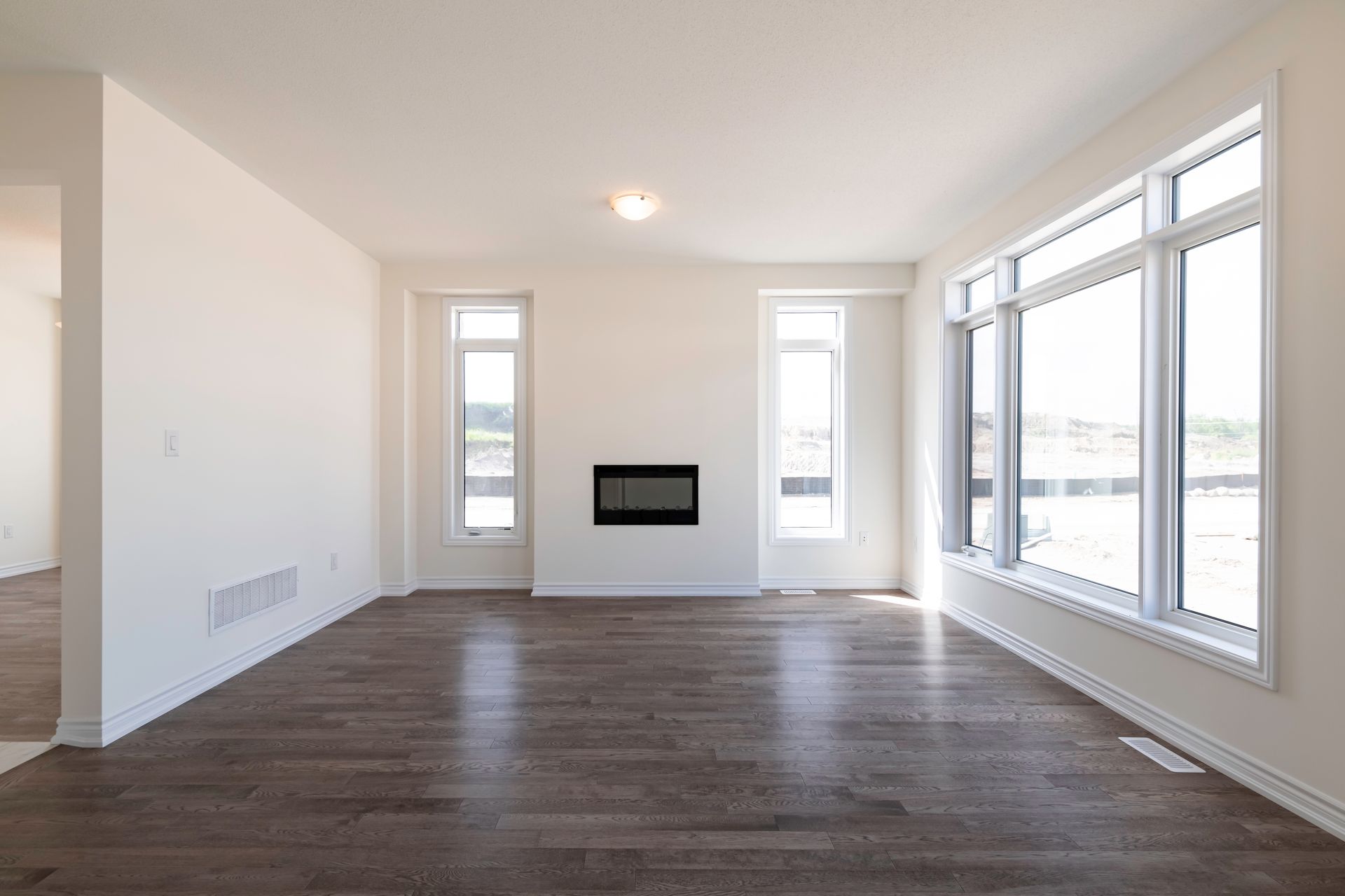 an empty living room with hardwood floors and a fireplace .