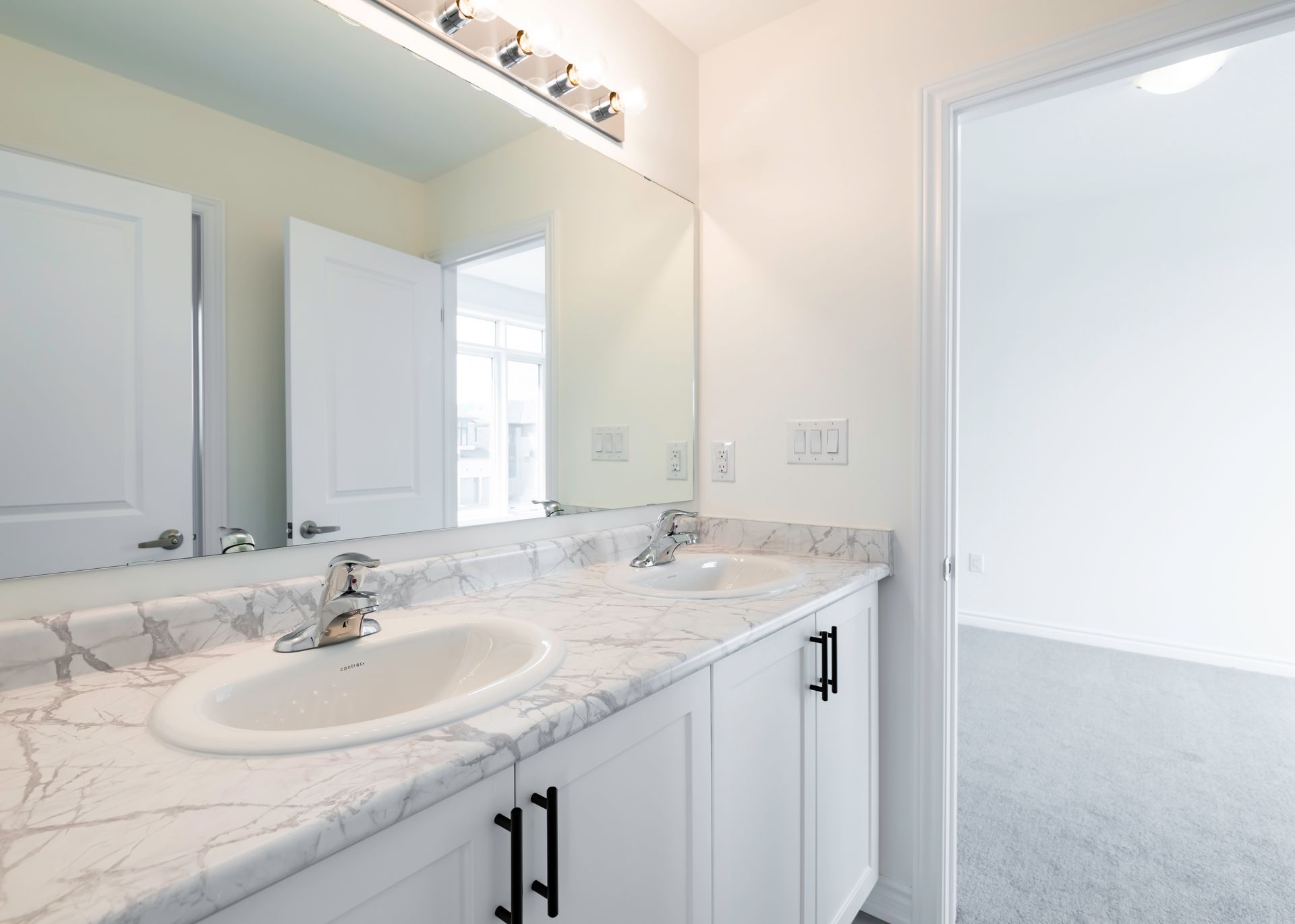 A bathroom with two sinks and a large mirror.