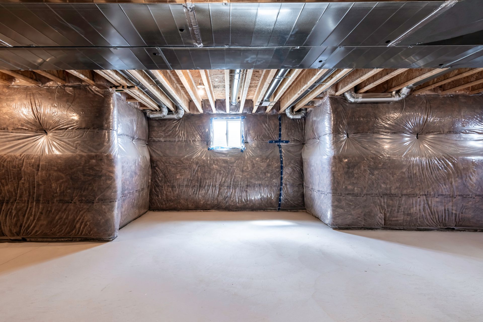 An empty basement with a lot of insulation on the walls and ceiling.