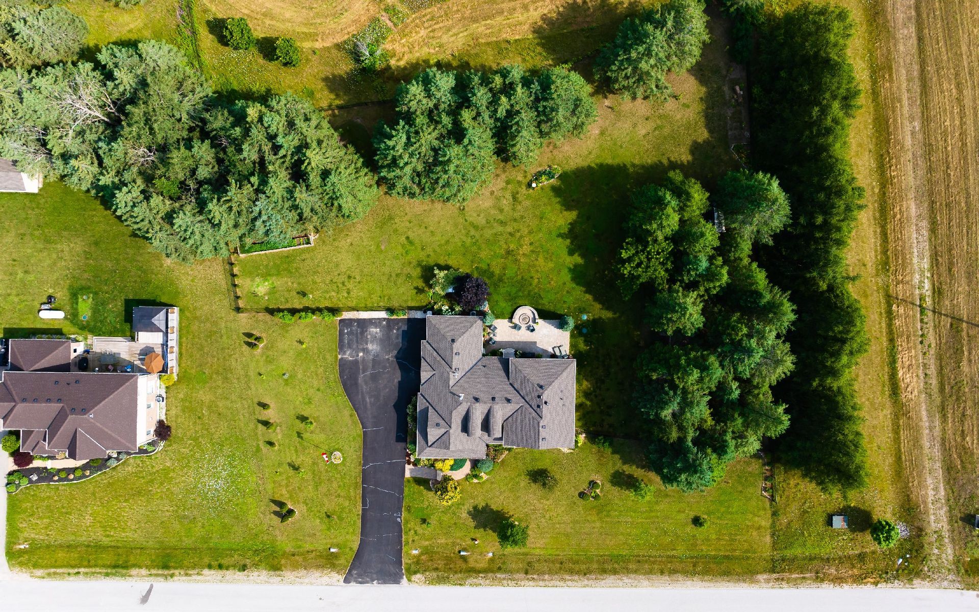 An aerial view of a house surrounded by trees and grass.
