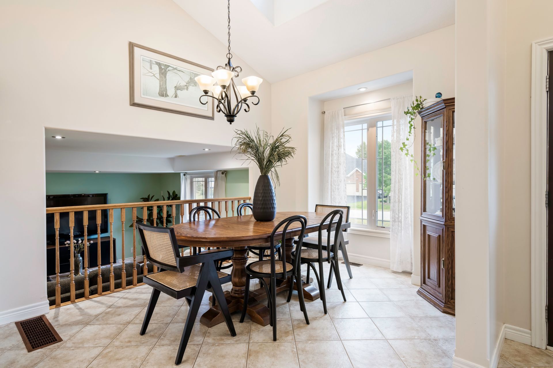 A dining room with a table and chairs and a chandelier.