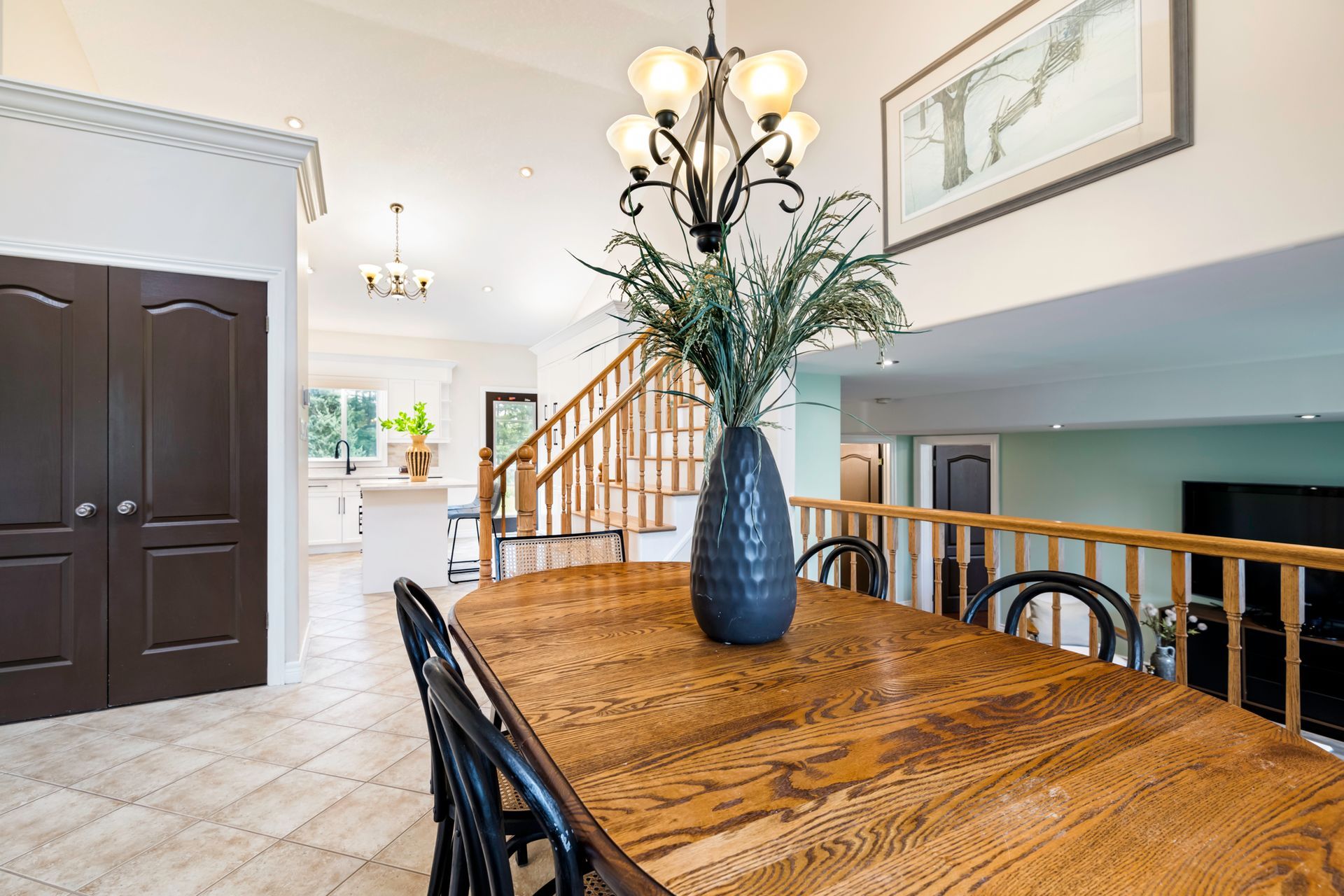 A dining room table with a vase of flowers on it.