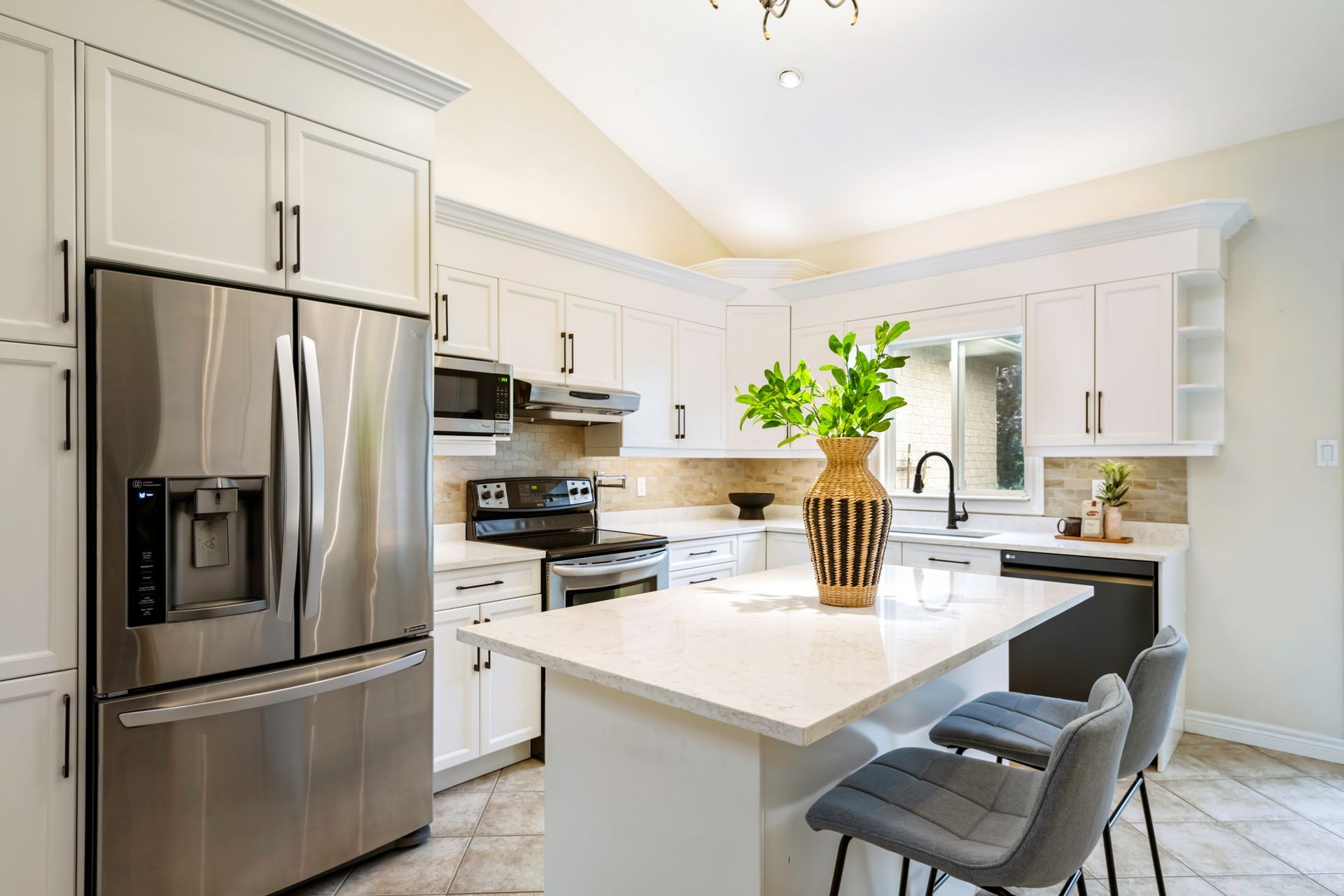 A kitchen with stainless steel appliances and white cabinets.