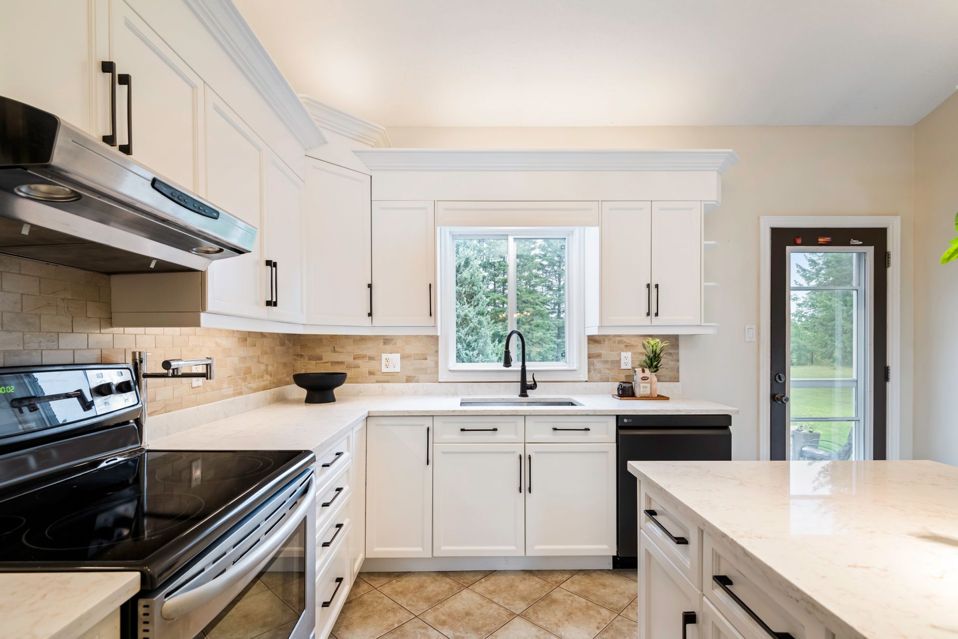 A kitchen with white cabinets , stainless steel appliances , and a large island.