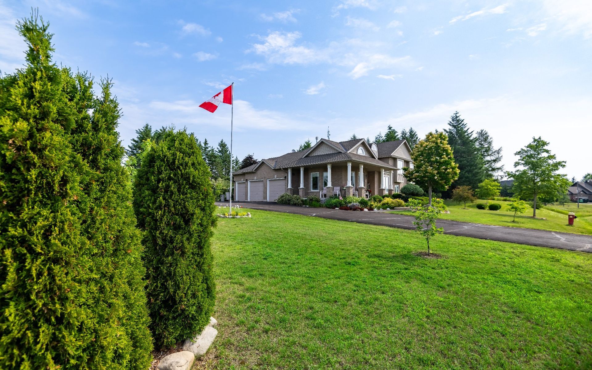 A large house with a canadian flag flying in front of it.