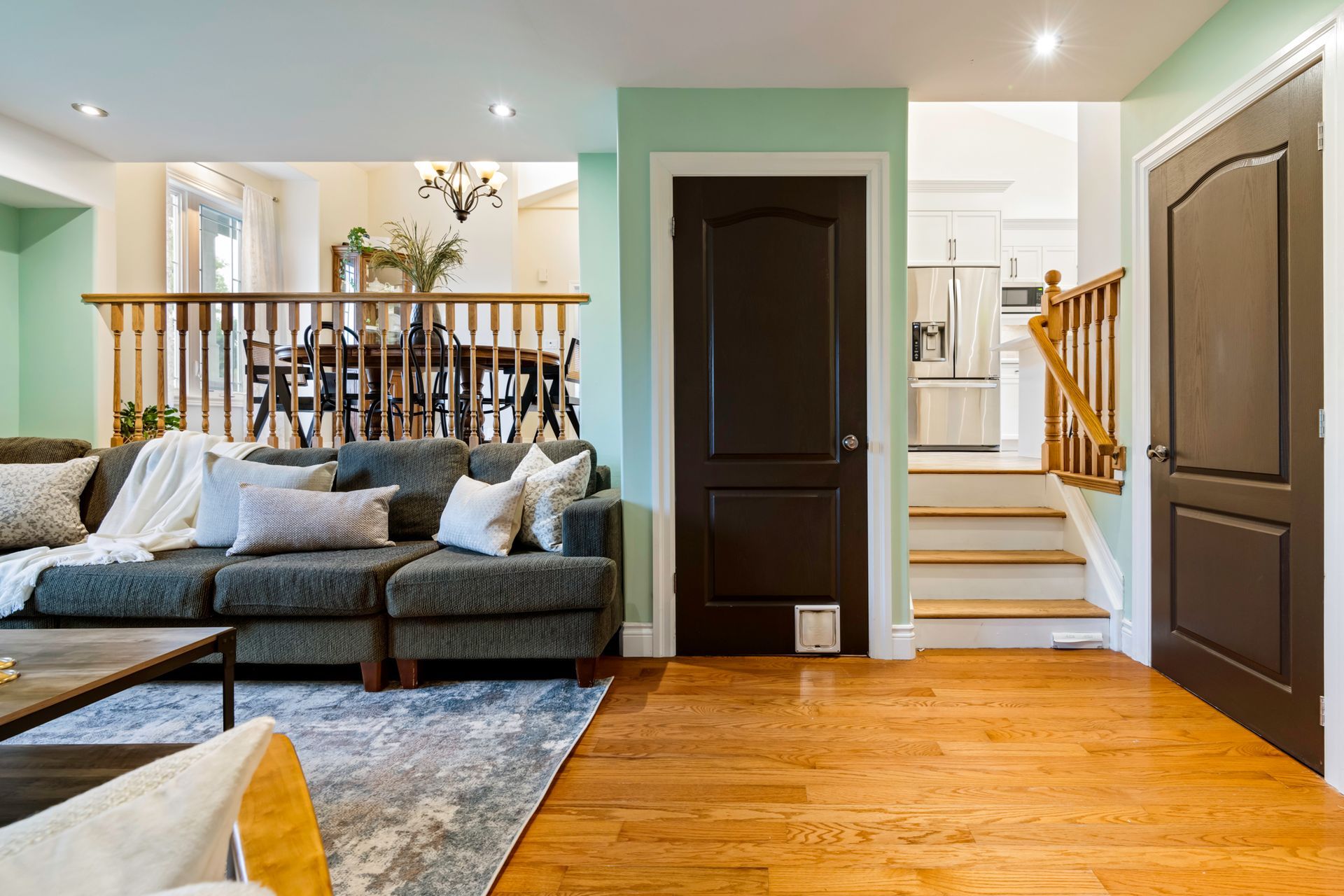 A living room with a couch , coffee table , and stairs.