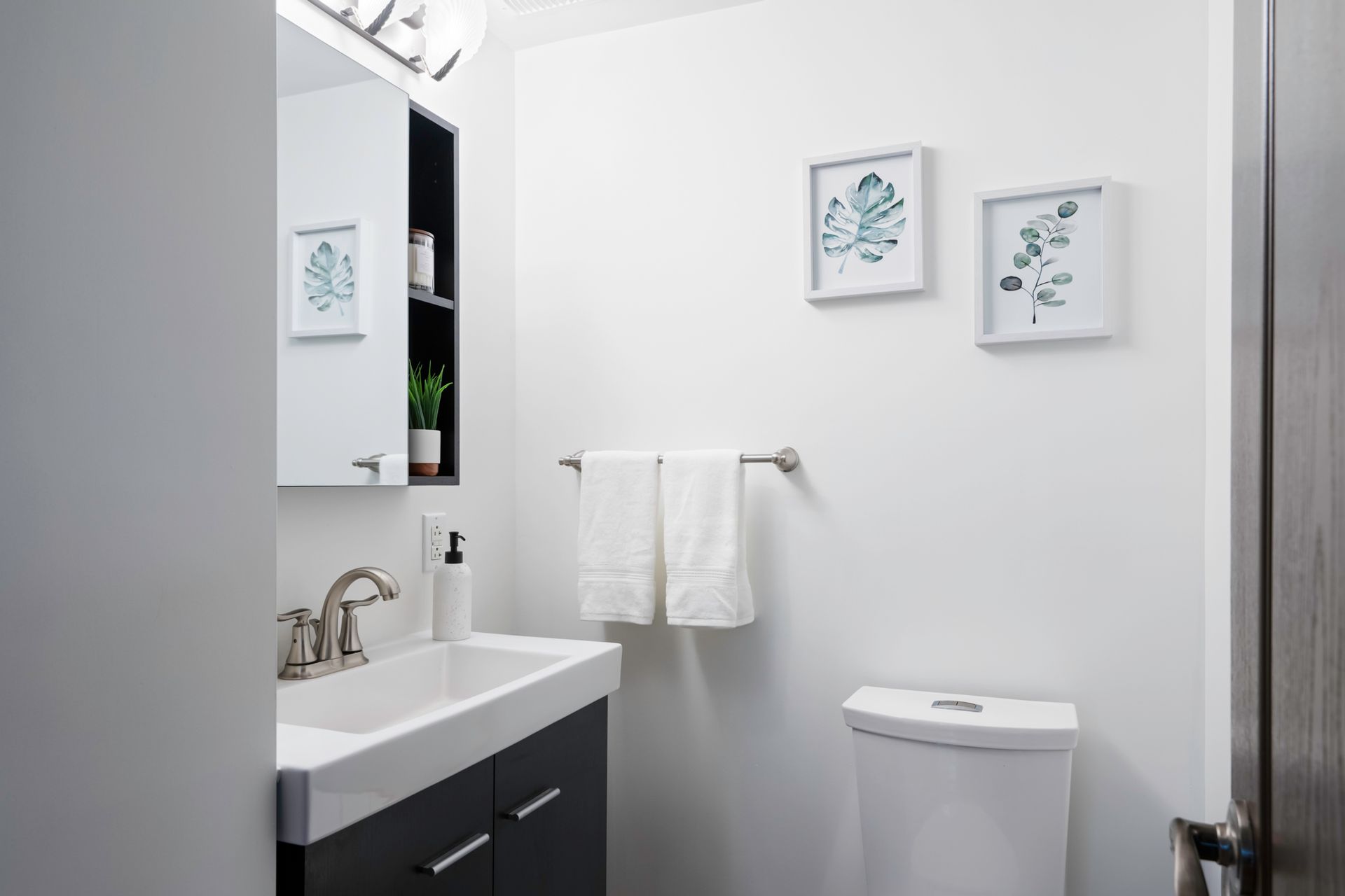 A bathroom with a sink , toilet and mirror.