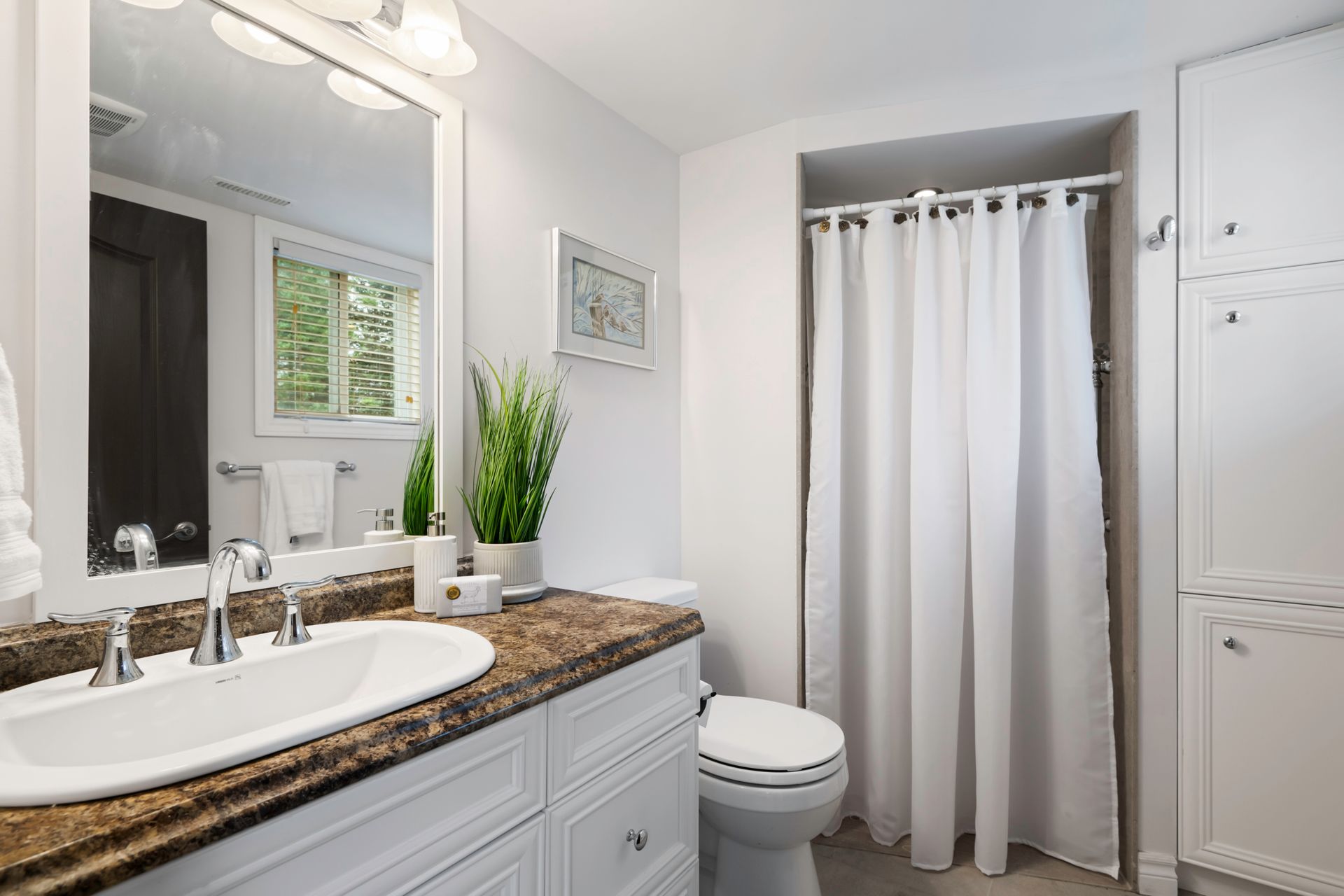 A bathroom with a sink , toilet and shower curtain.