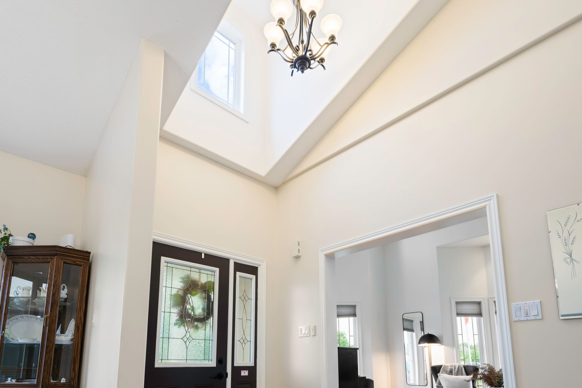 A hallway in a house with a chandelier hanging from the ceiling.
