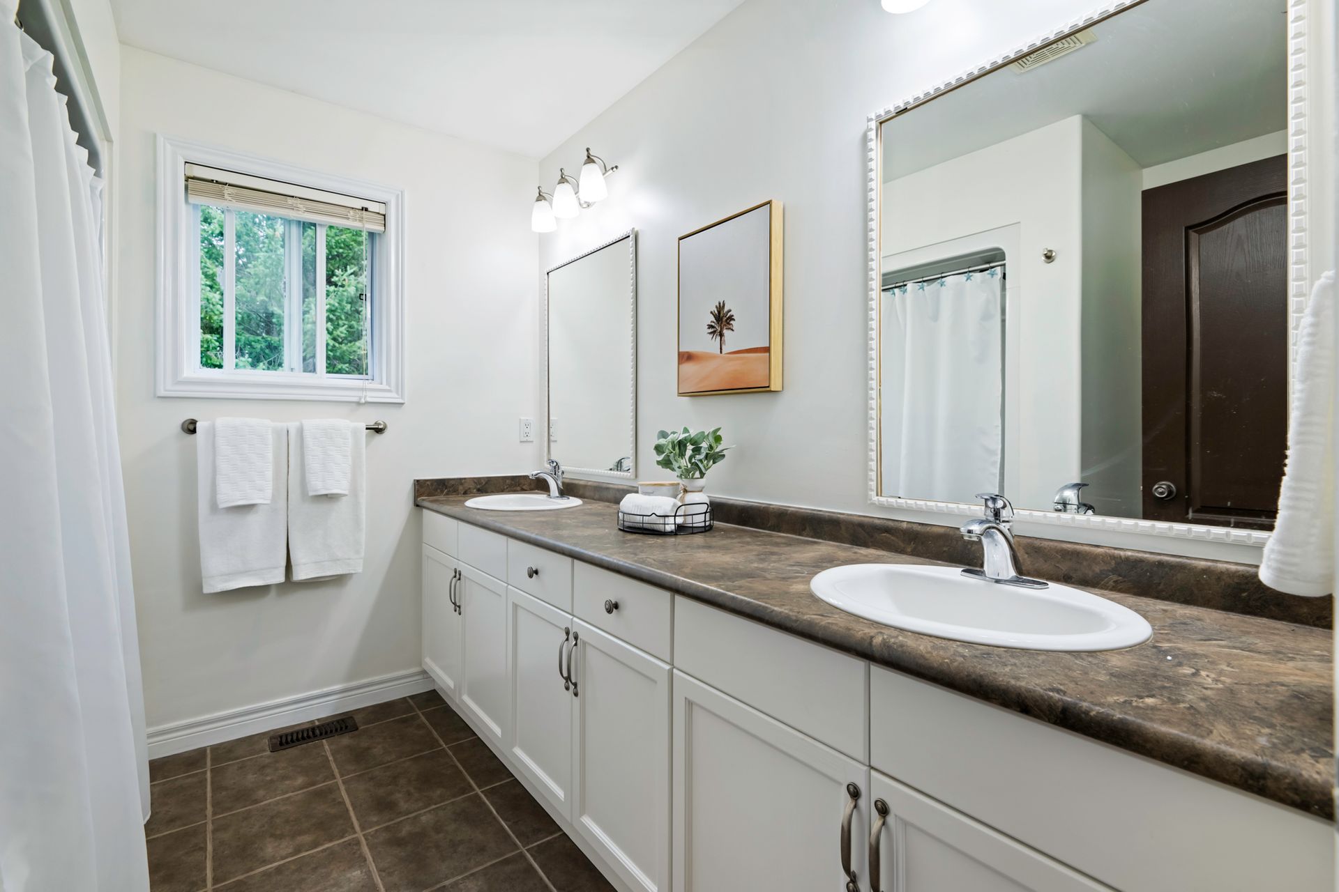 A bathroom with two sinks and a large mirror.