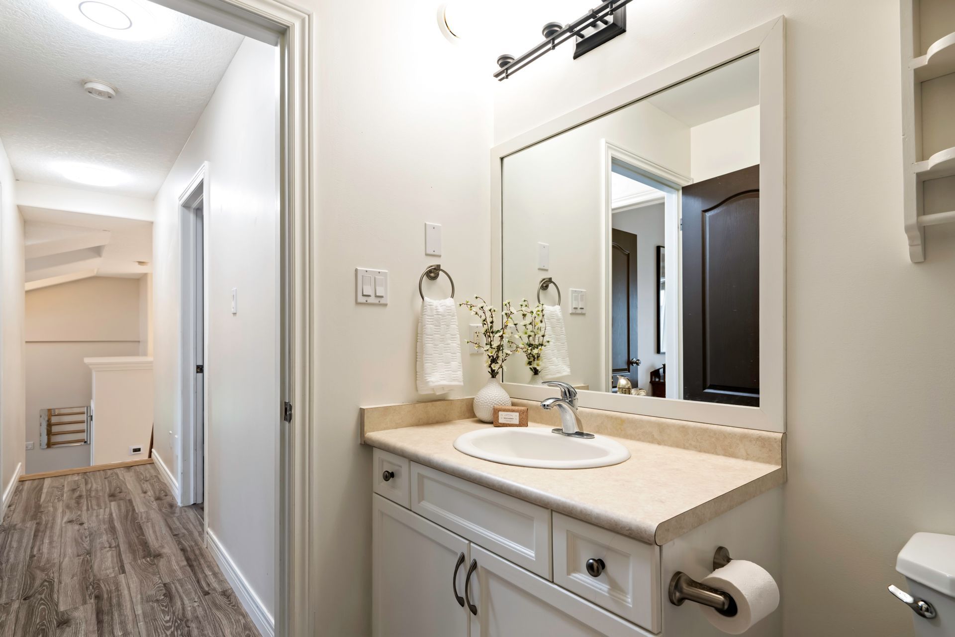 A bathroom with a sink , mirror and toilet.