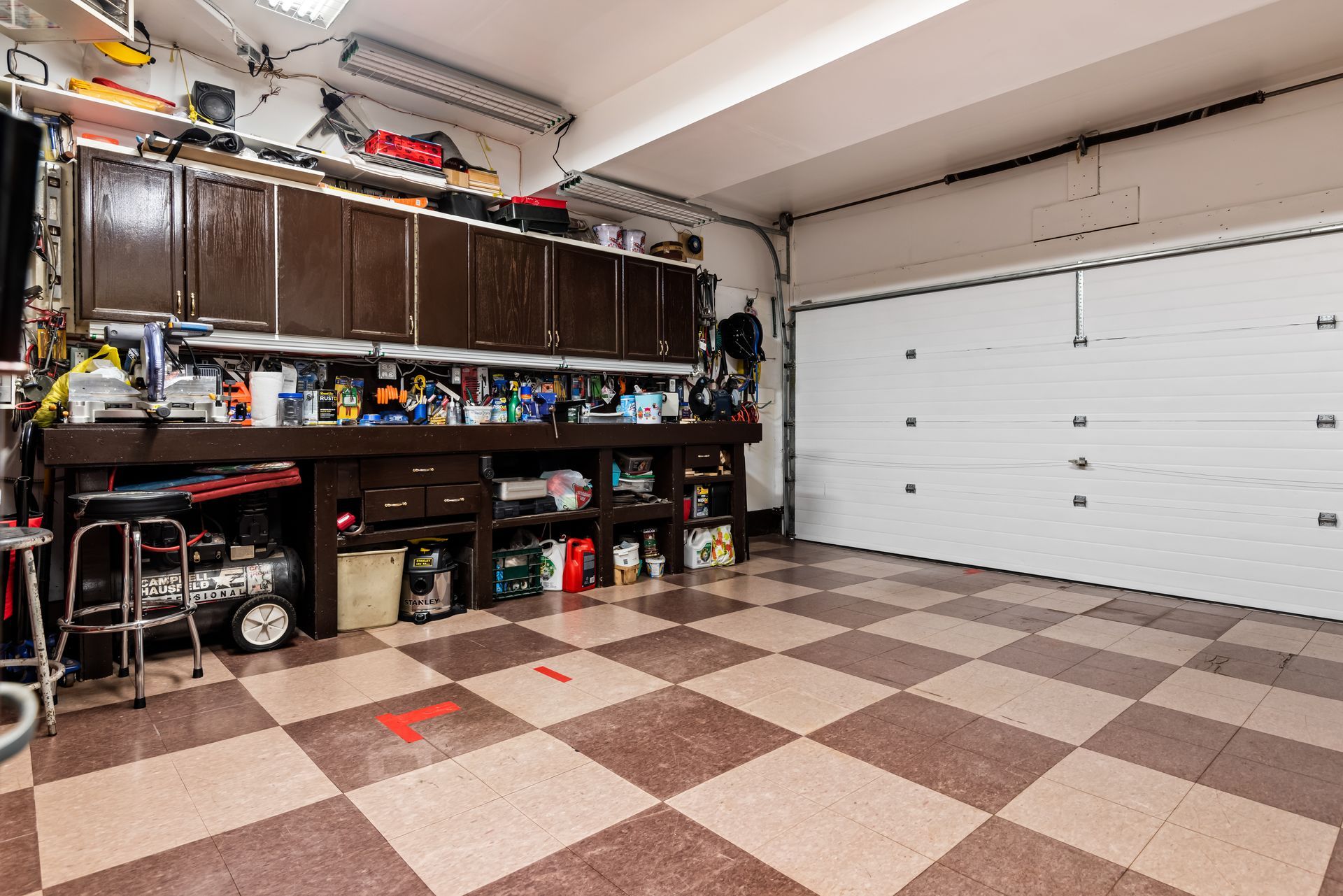 A garage with a checkered floor and a white garage door