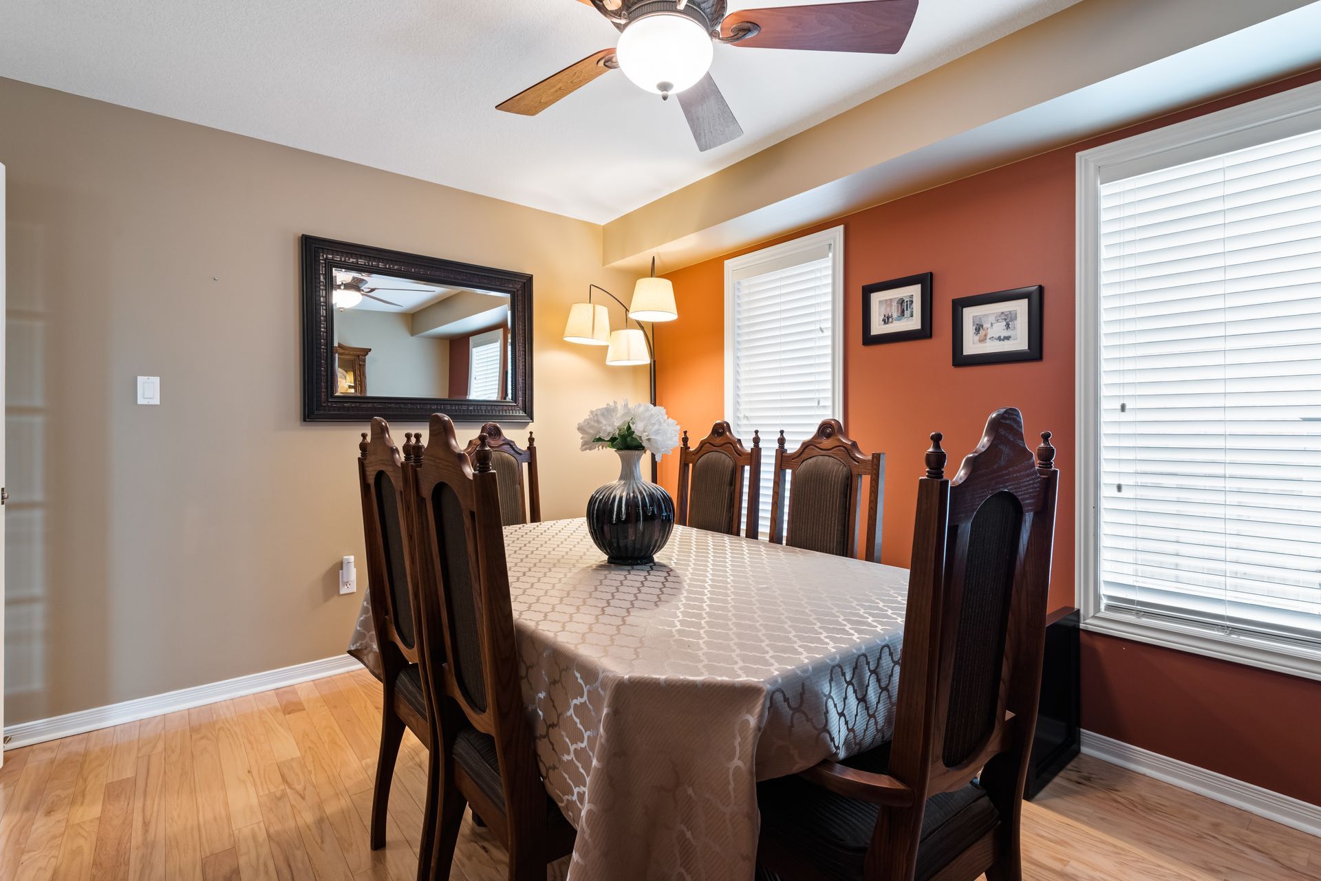 A dining room with a table and chairs and a ceiling fan.