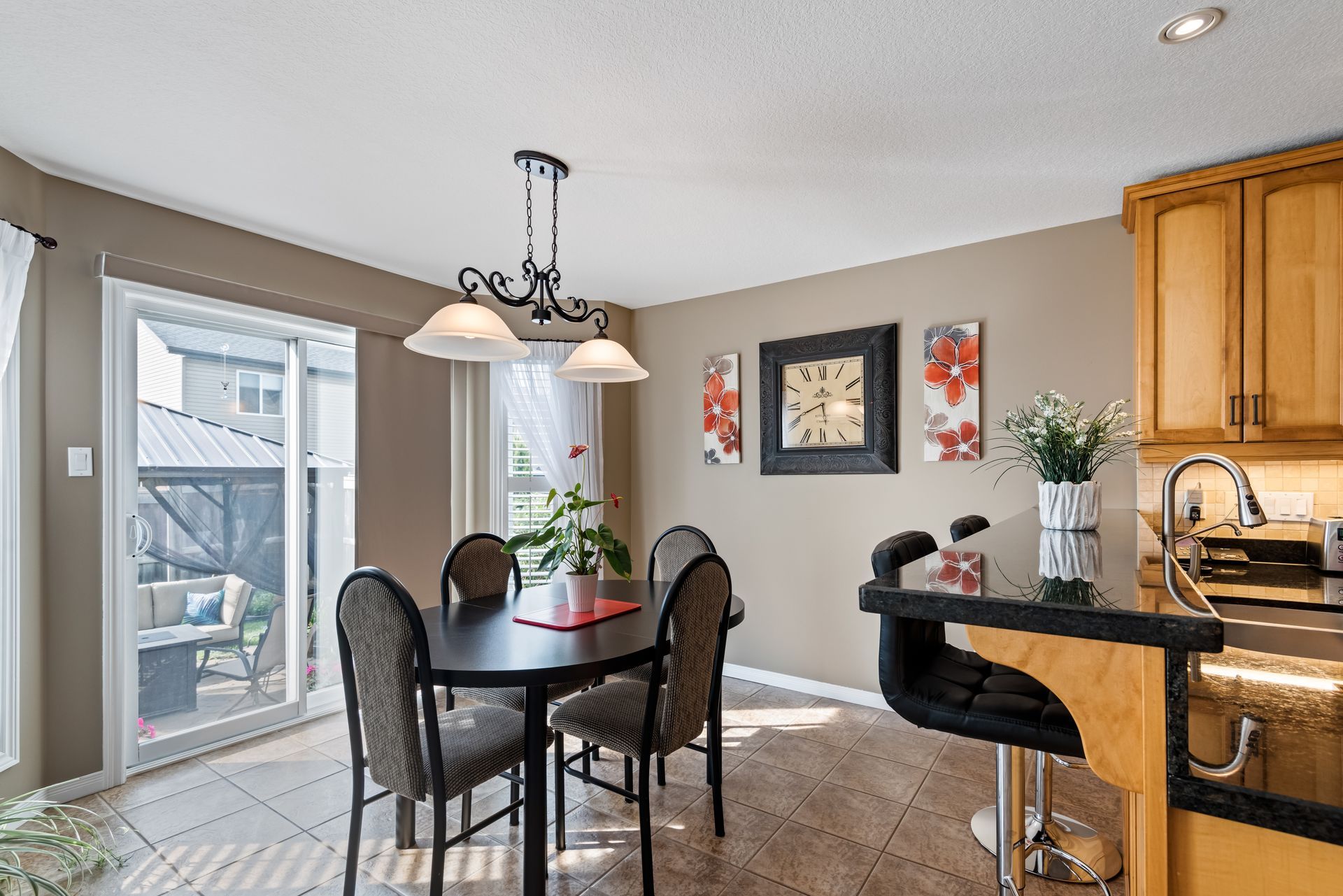 A dining room with a table and chairs and a kitchen.