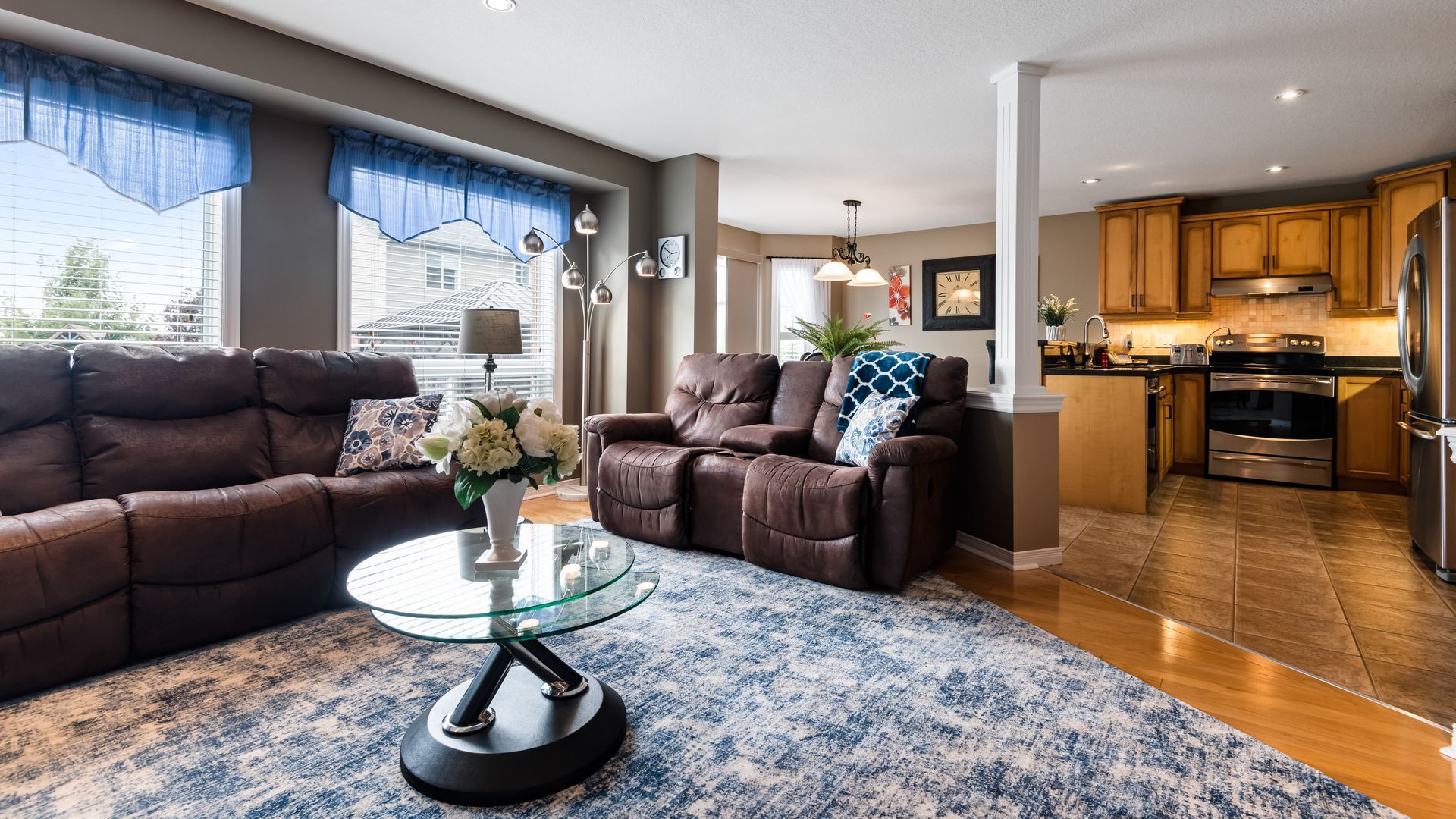 A living room with a couch , chairs , a coffee table and a rug.