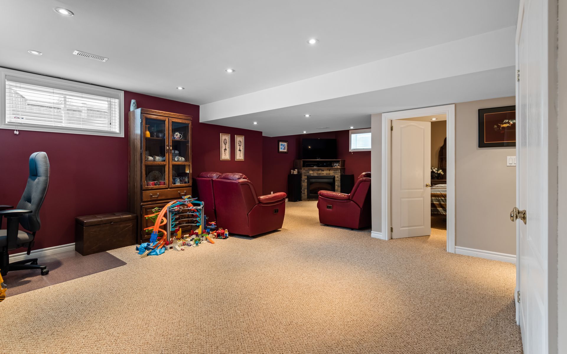 A basement with a lot of furniture and a fireplace.