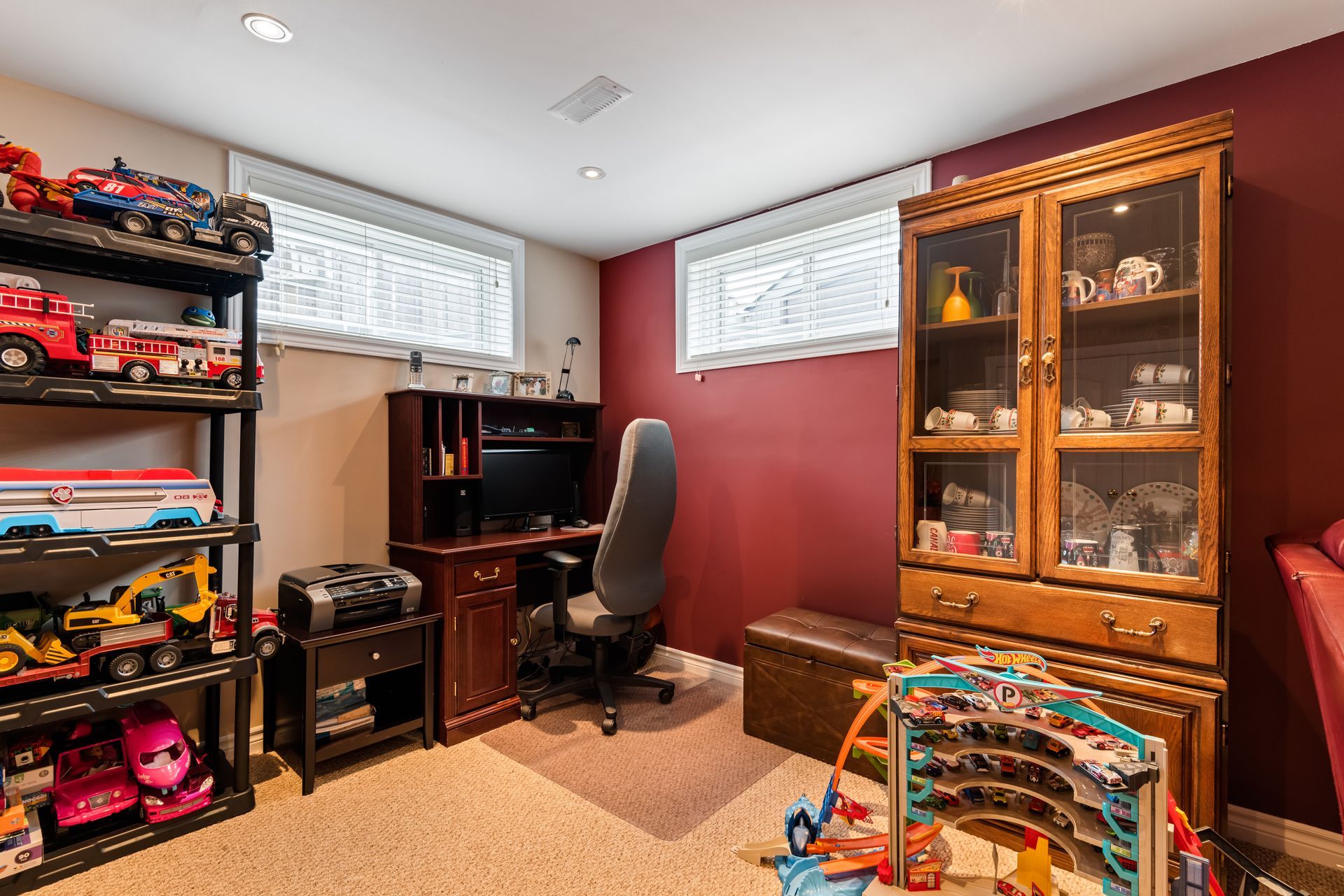 A basement with a lot of toys and a desk.
