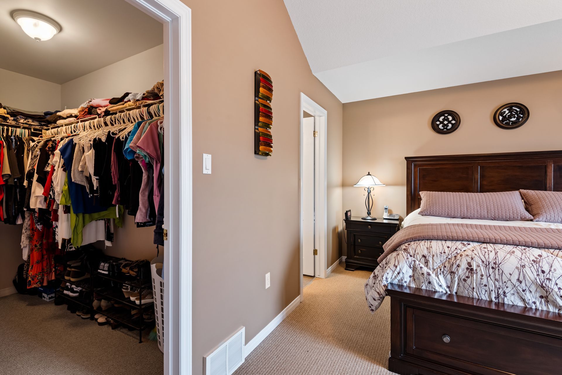 A bedroom with a walk in closet and a bed.