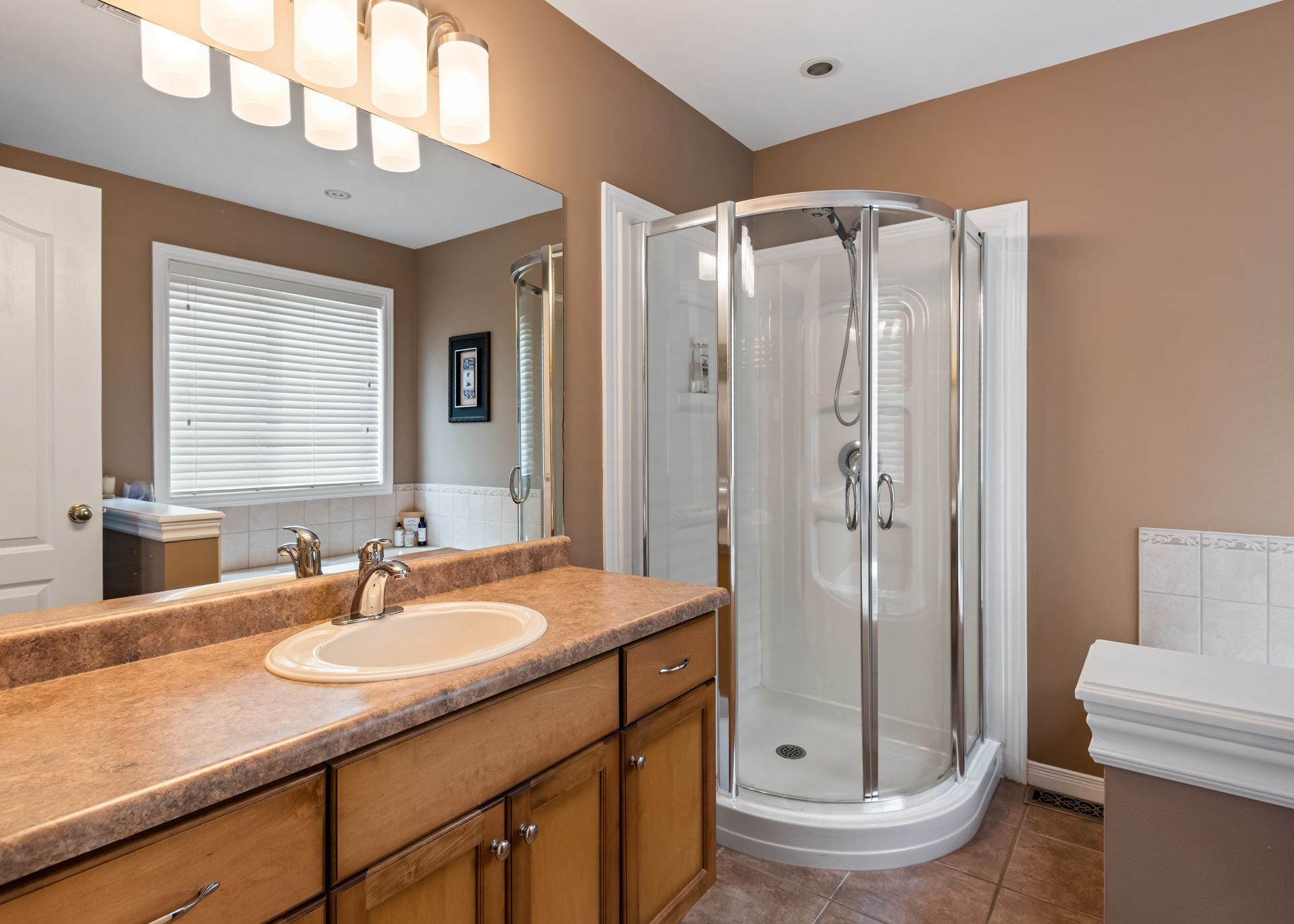 A bathroom with a shower , sink , and mirror.