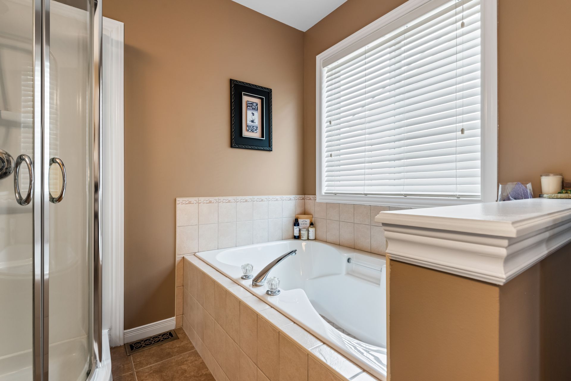 A bathroom with a tub , shower , and window.
